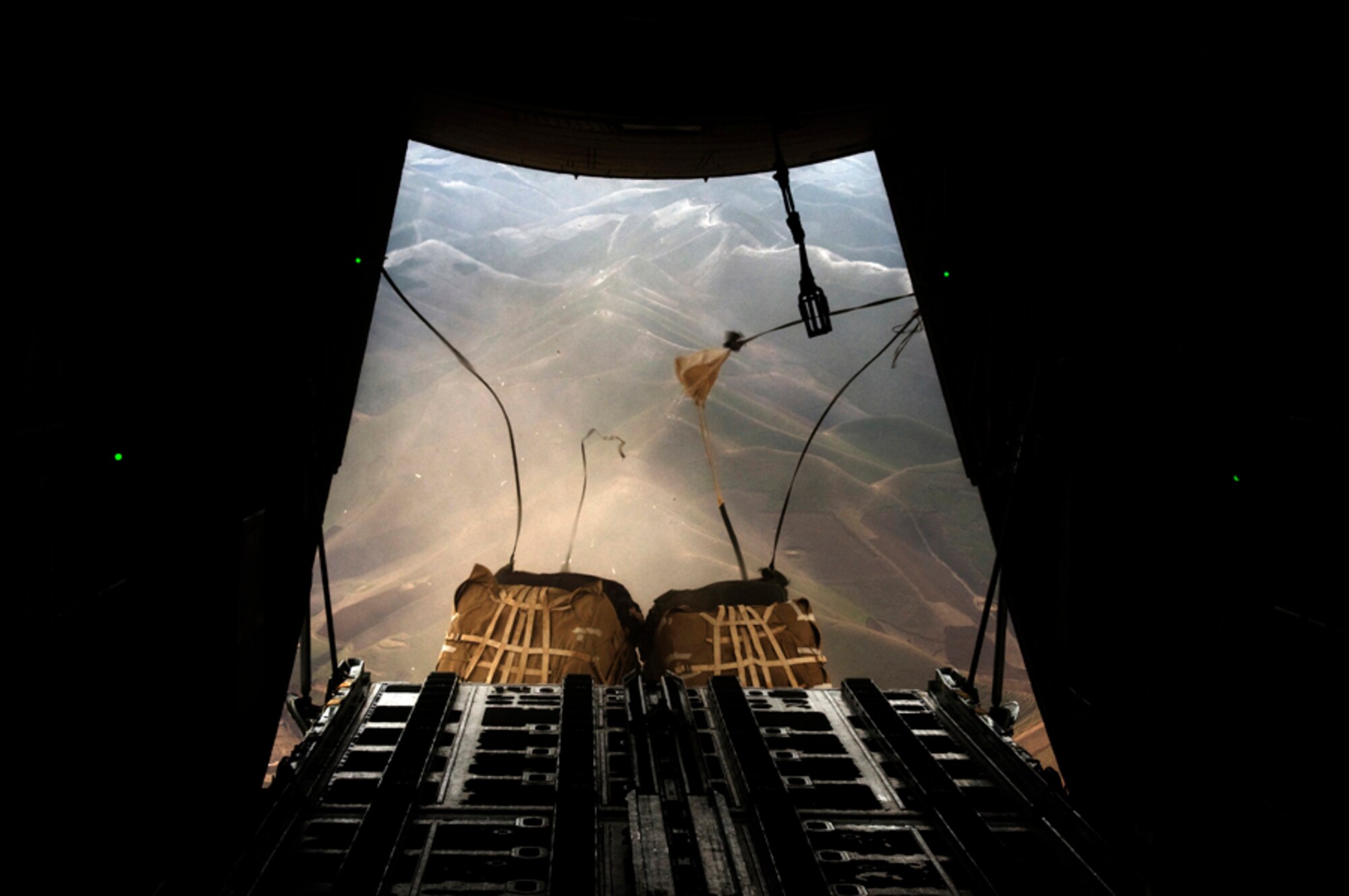 HERAT, Afghanistan -- Parachutes attached to cargo pallets begin to open and slow the pallets' descent as they fall toward a forward operating base in Badghis Province, Afghanistan, Feb. 26, 2011. The pallets were airdropped from an Italian C-130J Hercules to resupply the FOB and 16 surrounding combat outposts. (U.S. Air Force photo/Tech. Sgt. Kevin Wallace)