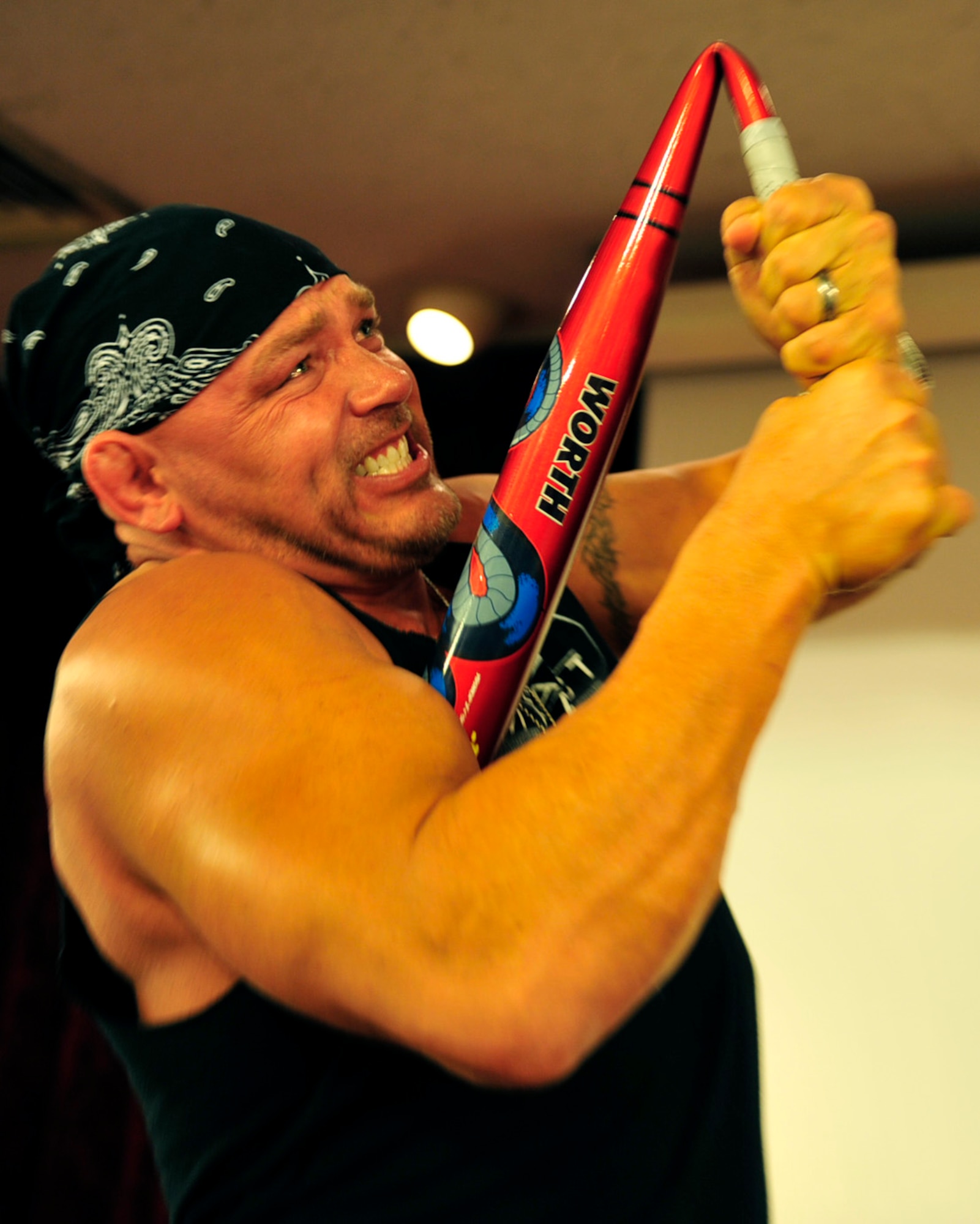 Ron Waterman, a former World Wresting Entertainment wrestler, Ultimate Fighting Championship competitor and a member of Team Impact, bends a steel bar during the 2011 National Prayer Breakfast at Kadena’s Rocker NCO Club, March 10. This year the National Prayer Breakfast had the privilege of having Mr. Waterman and two other members of Team Impact as guest performers. (U.S. Air Force photo/Senior Airman Sara Csurilla)