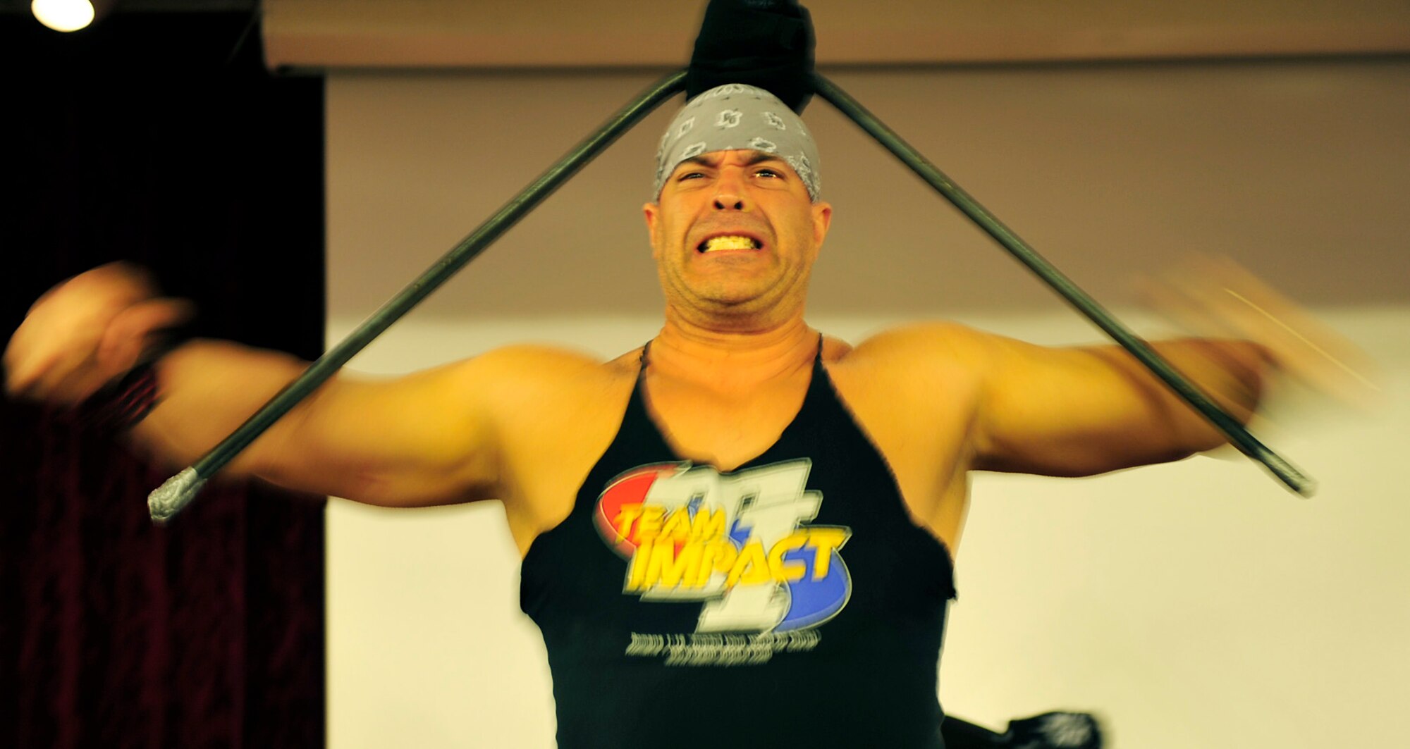 Cesar Arocha, Sr., a body building champion from Caracas, Venezuela and a member of Team Impact, bends a steel bar during the 2011 National Prayer Breakfast at Kadena’s Rocker NCO Club, March 10. This year, the National Prayer Breakfast had the privilege of having Mr. Arocha and two other members of Team Impact as guest performers along with the Kadena Chapel Combined Choir. (U.S. Air Force photo/Senior Airman Sara Csurilla)