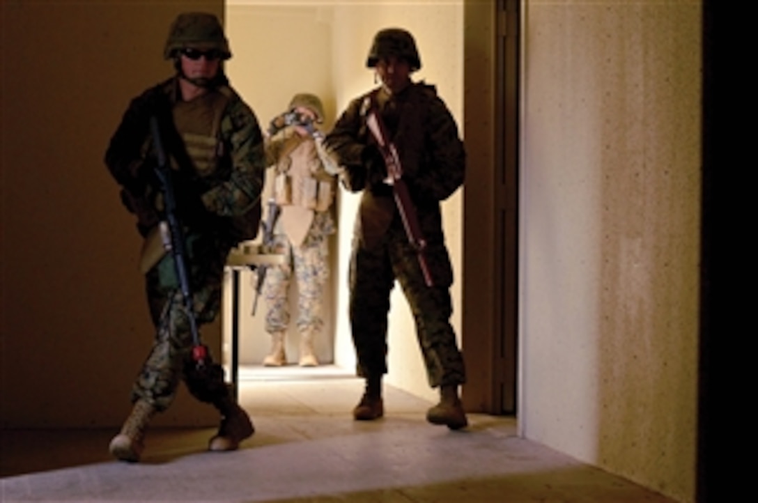 Marines with Military Police Company secure a building and begin to process the scene by photographing and recording the rooms during a forensic material collection and exploitation course in the Central Training Area on March 8, 2011.  