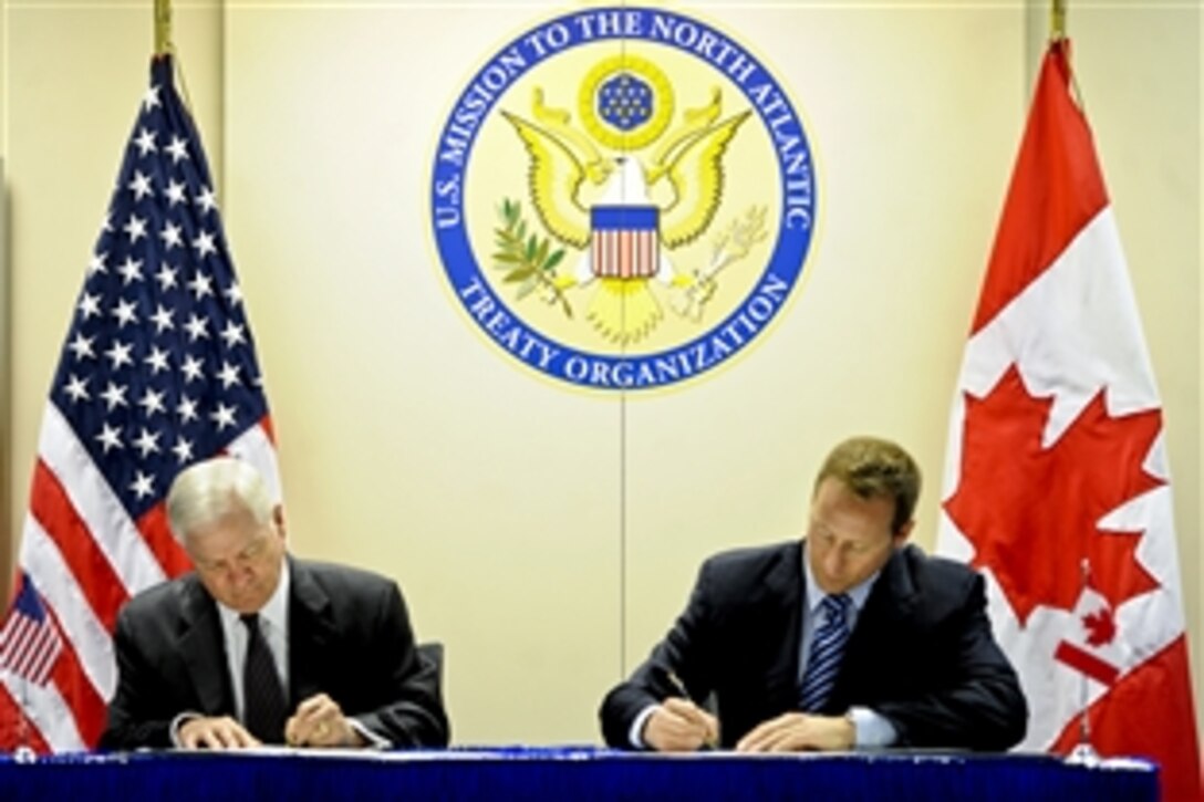 U.S. Defense Secretary Robert M. Gates, left, and Canadian Defense Minister Peter MacKay sign the U.S. and Canada Space Situational Awareness Partnership at NATO headquarters in Brussels, Belgium, March 10, 2011. Gates is in Belgium to attend NATO defense ministers meetings.