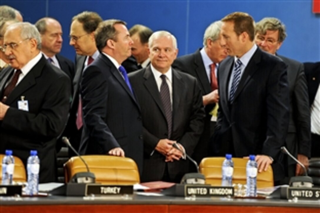 U.S. Defense Secretary Robert M. Gates, center foreground, talks with U.K. Defense Minister Liam Fox, left, and Canadian Defense Minister Peter MacKay during a meeting for NATO defense ministers at NATO headquarters in Brussels, Belgium, March 10, 2011.