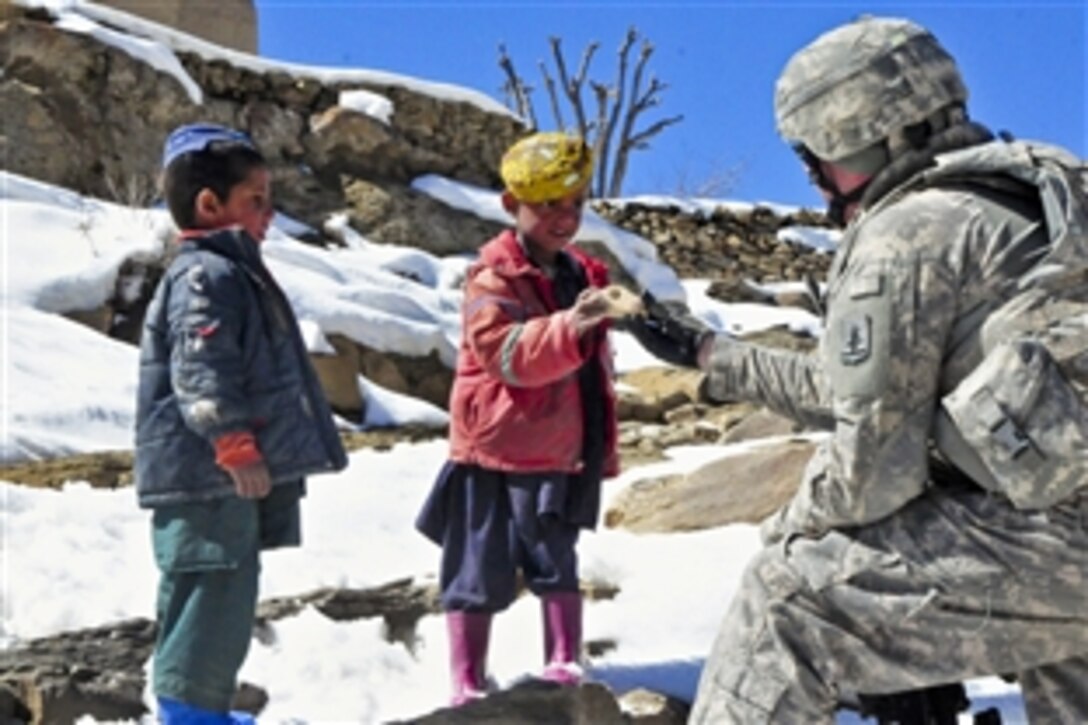 U.S. Army Staff Sgt. Christopher Herndon hands out wooden toys to village children in Paktika province, Afghanistan, March 9, 2011. Herndon, a Nebraska Guardsman, is assigned to the 623rd Engineer Company.