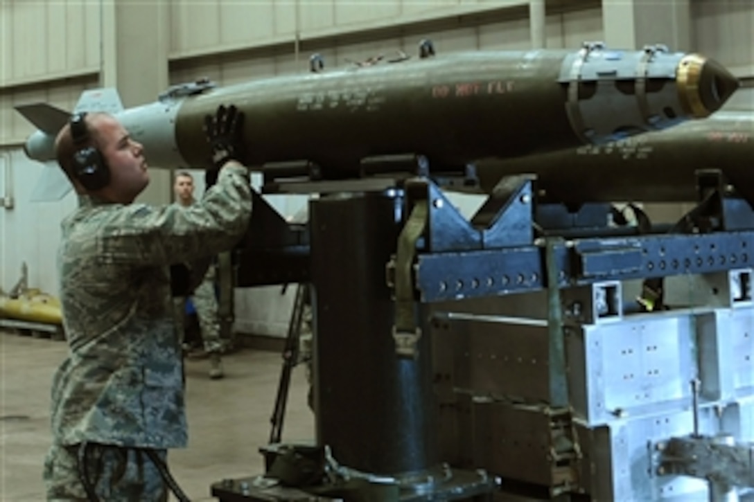 U.S. Air Force Senior Airman Ty Morse, a weapons load crew team chief with the 37th Bomb Squadron, 28th Bomb Wing, stabilizes a mock guided bomb unit-38 on a munitions rack during a load crew competition at Ellsworth Air Force Base in South Dakota on March 4, 2011.  The competition featured two four-person teams from the 34th and 37th Bomb Squadrons who were rated on their time and efficiency.  