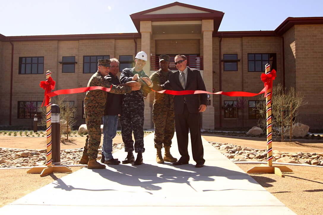 (From left to right) Colonel Osamah Jammal, Marine Corps Base Camp Pendleton Chief of Staff; Oscar Villa Franca, owner of Dimension Construction; Navy Cmdr. Scott King, resident officer-in-charge of construction; CWO4 Brian Mitchell, postal director and Donald Darling, former postal director; all cut a ceremonial ribbon marking the grand opening of the base’s new Mail Processing Facility, March 10.