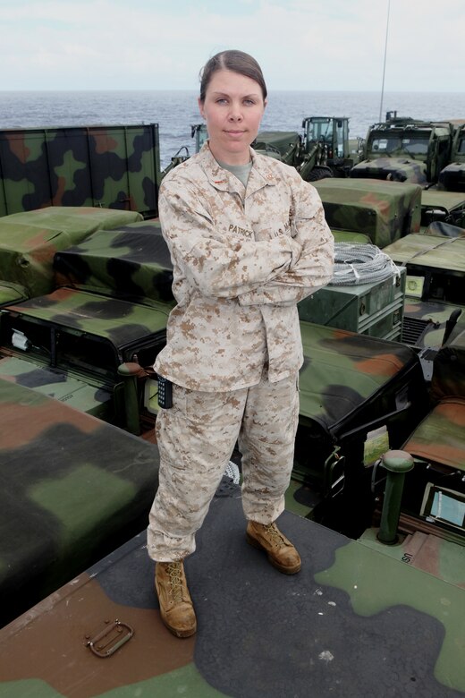 Chief Warrant Officer 2 Erin Patrick, combat cargo officer aboard the USS Harpers Ferry (LSD 49), stands atop vehicles and equipment of the 31st Marine Expeditionary Unit March 11.  As the CCO, Patrick coordinates the loading, storage, and offloading of all 31st MEU equipment on ship.  Patrick has been deployed 18 of the last 24 months, away from her husband and four children.  She is one of the Marine Corps’ many professionals who sacrifice time with family to serve their country.