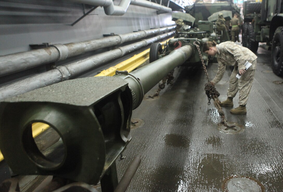 Chief Warrant Officer 2 Erin Patrick, combat cargo officer aboard the USS Harpers Ferry (LSD 49), stands atop vehicles and equipment of the 31st Marine Expeditionary Unit March 11.  As the CCO, Patrick coordinates the loading, storage, and offloading of all 31st MEU equipment on ship.  Patrick has been deployed 18 of the last 24 months, away from her husband and four children.  She is one of the Marine Corps’ many professionals who sacrifice time with family to serve their country.