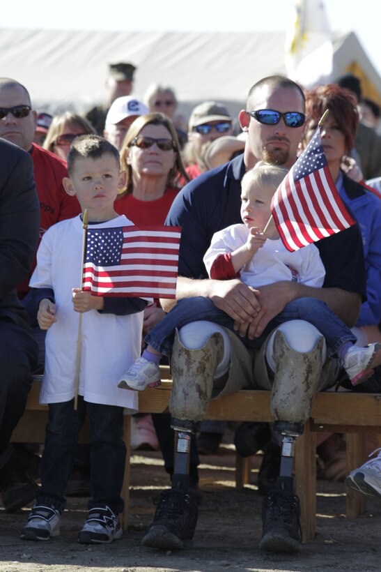 Dylan Gray, a Marine veteran amputee, sits with his son and daughter in Wellington, Nev., during a wall raising ceremony for his home March 11, 2011. Gray’s home is being built by the Homes For Our Troops organization.