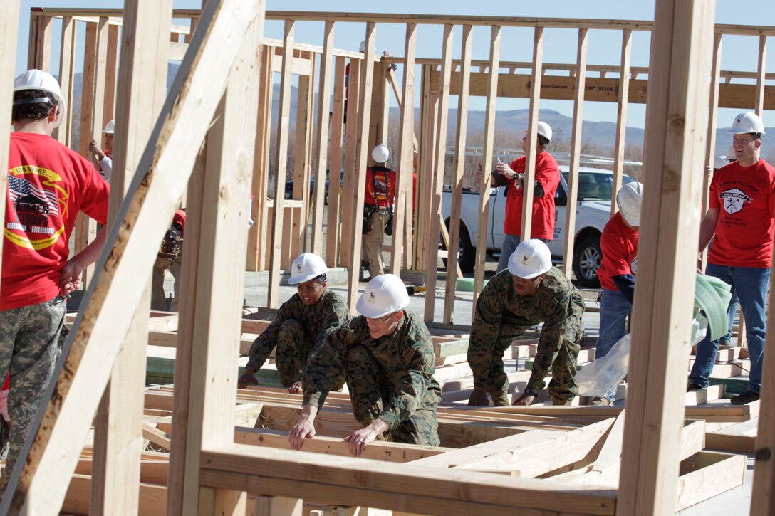 Volunteers work to build a house being donated to Dylan Gray, a Marine veteran amputee, after a wall raising ceremony March 11, 2011, in Wellington, Nev.