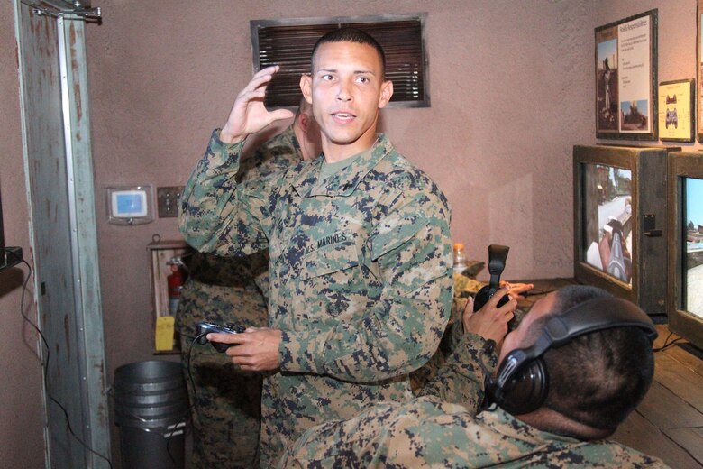 Corporal David LeonCartagena, a supply warehouseman with Consolidated Material Support Center, Headquarters Battalion, provides instructions to his team in the minutes before entering the final module of the Mobile Counter-IED Interactive Trainer during training March 11, 2011. LeonCartagena was assigned as the lead insurgent in an interactive exercise, where an insurgent ambush team faces off against a mounted patrol.