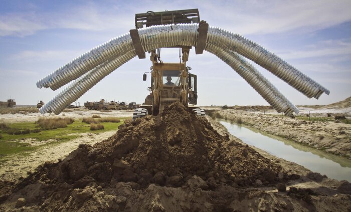 Combat engineers and heavy equipment operators with Combat Logistics Battalion 3, 2nd Marine Logistics Group (Forward), use heavy equipment vehicles to install metal culverts during a civil development project in Haji Hanif Khan, Afghanistan, March 11. The combat engineers and heavy equipment operators of CLB-3's Engineer Company have conducted several civil development and military construction projects throughout Afghanistan since they arrived in October.