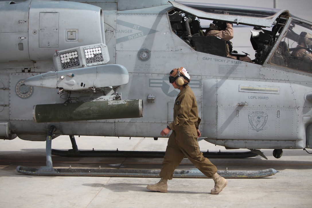 Cpl. Kelsey J. Canoy, a helicopter mechanic with Marine Light Attack Helicopter Squadron 169, inspects the exterior of an AH-1W Cobra for launch aboard Camp Bastion, Afghanistan, March 11. “We make sure everything is closed and tightened down on the exterior for flight.”::r::::n::::r::::n::::r::::n::