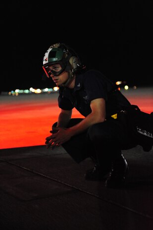 NELLIS AIR FORCE BASE, Nev., --  U.S. Navy Aviation Electricians' Mate 3rd Class Angelo Fiore, VAQ-138 Squadron, waits for the signal to pull out the chocks for an EA-18G Growler during Red Flag 11-3, Nellis Air Force Base, Nev., March 10.  Red Flag is a realistic combat training exercise involving the air forces of the United States and its allies.  The exercise is hosted north of Las Vegas on the Nevada Test and Training Range.   (U.S. Air Force Photo by Staff Sgt. William P. Coleman)
