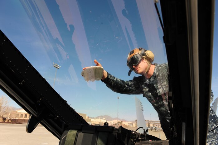 NELLIS AIR FORCE BASE, Nev., --  U.S. Navy Aviation Electronic's Mate 3rd Class Matthew Benson, VAQ-138 squadron, cleans the canopy of a EA-18G Growler during Red Flag 11-3, Nellis Air Force Base, nev., March 8.  Red Flag is a realistic combat training exercise involving the air forces of the United States and its allies.  The exercise is hosted north of Las Vegas on the Nevada Test and Training Range.   (U.S. Air Force Photo by Staff Sgt. William P. Coleman)