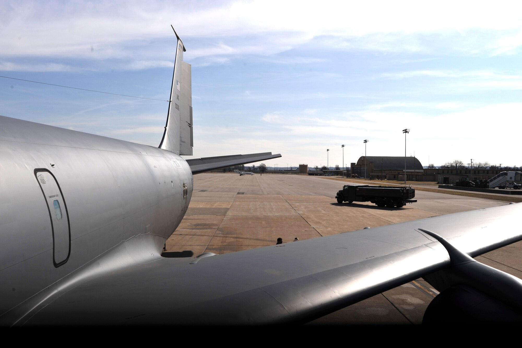 An R-11 fuels truck moves across the flightline behind a KC-135 Stratotanker at Scott Air Force Base, Ill., on March 1, 2011.   (U.S. Air Force Photo/Master Sgt. Scott T. Sturkol)