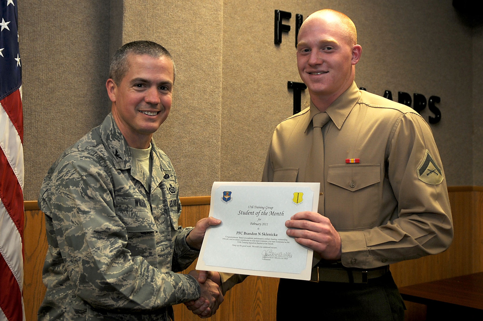 GOODFELLOW AIR FORCE BASE, Texas -- Marine Lance Cpl. Brandon Sklenicka, a 312th Training Squadron student, receives his February Student of the Month certificate from Col. J.D. Willis, 17th Training Group Commander.  (U.S. Air Force photo/Staff Sgt. Heather L. Rodgers)
