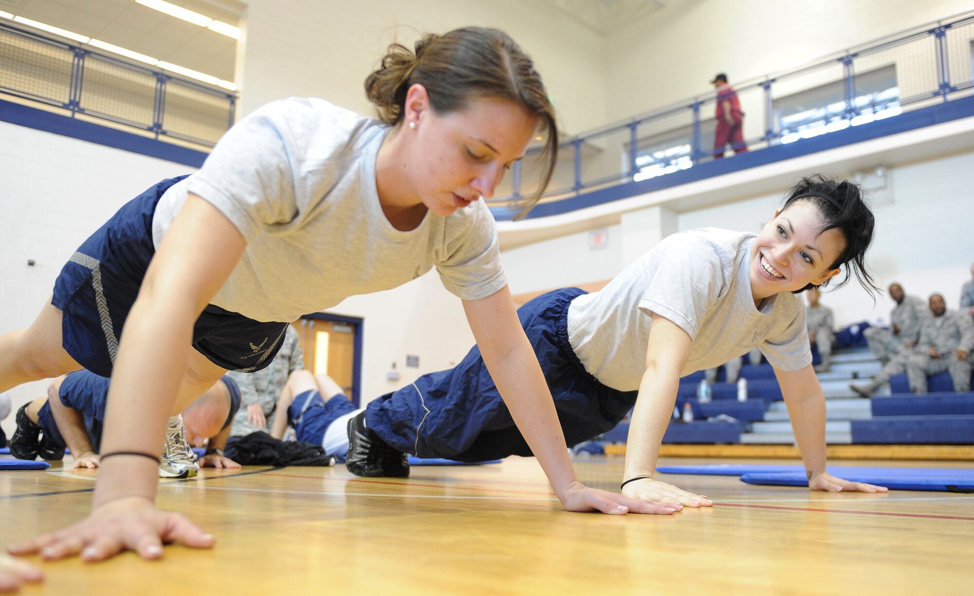 Push-up-A-Thon/Sit-up-A-Thon Participants Senior Airman Crystal McNeese encourages Senior Airman Jessica Ray, 30th Intelligence Squadron training managers,  as they compete against 57 other participants in the Push-up-A-Thon/Sit-up-A-Thon at Langley Air Force Base, Va., March 11, 2011. The Langley first sergeants sponsored this fitness event in order to raise money for the Enlisted Heritage Hall. (U.S. Air Force photo by Senior Airman Antoinette Gibson/Released)
