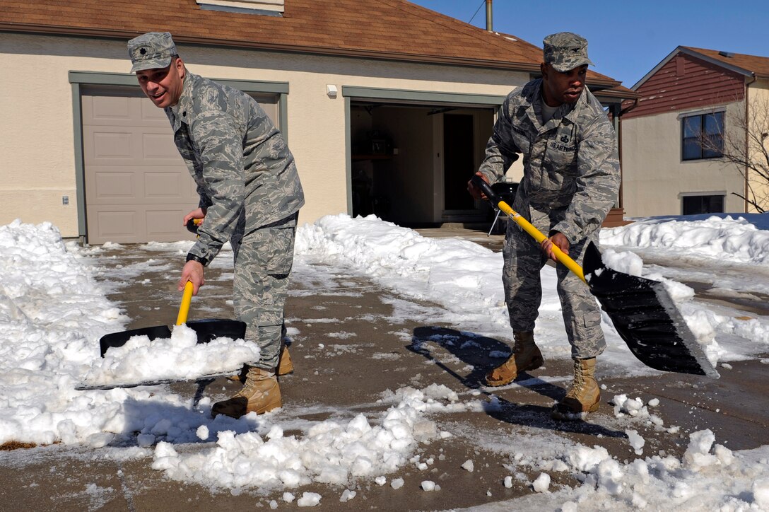 (Right) Col. Trent Edwards, 28th Mission Support Group commander, and Lt. Col. Matthew Joganich, 28th Civil Engineer Squadron commander, clear snow from a sidewalk in front of an unoccupied house in base housing on Ellsworth Air Force Base, S.D., March 9, 2011.  Colonel Edwards and Colonel Joganich remind base housing occupants to focus on community safety, especially for children walking to the bus stops by clearing snow on adjacent sidewalks within 24 hours after a snowfall. (U.S. Air Force photo/Staff Sgt. Marc I. Lane)