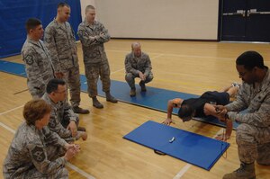 Langley first sergeants encourage John Masser, Fort Eustis Felker Army Airfield manager, during the Push-up-A-Thon/Sit-up-A-Thon at Langley Air Force Base, Va., March 11, 2011. As an individual competitor, Mr. Masser completed 324 push-ups in 10 minutes. (U.S. Air Force photo by Airman 1st Class Racheal Watson/Released) 