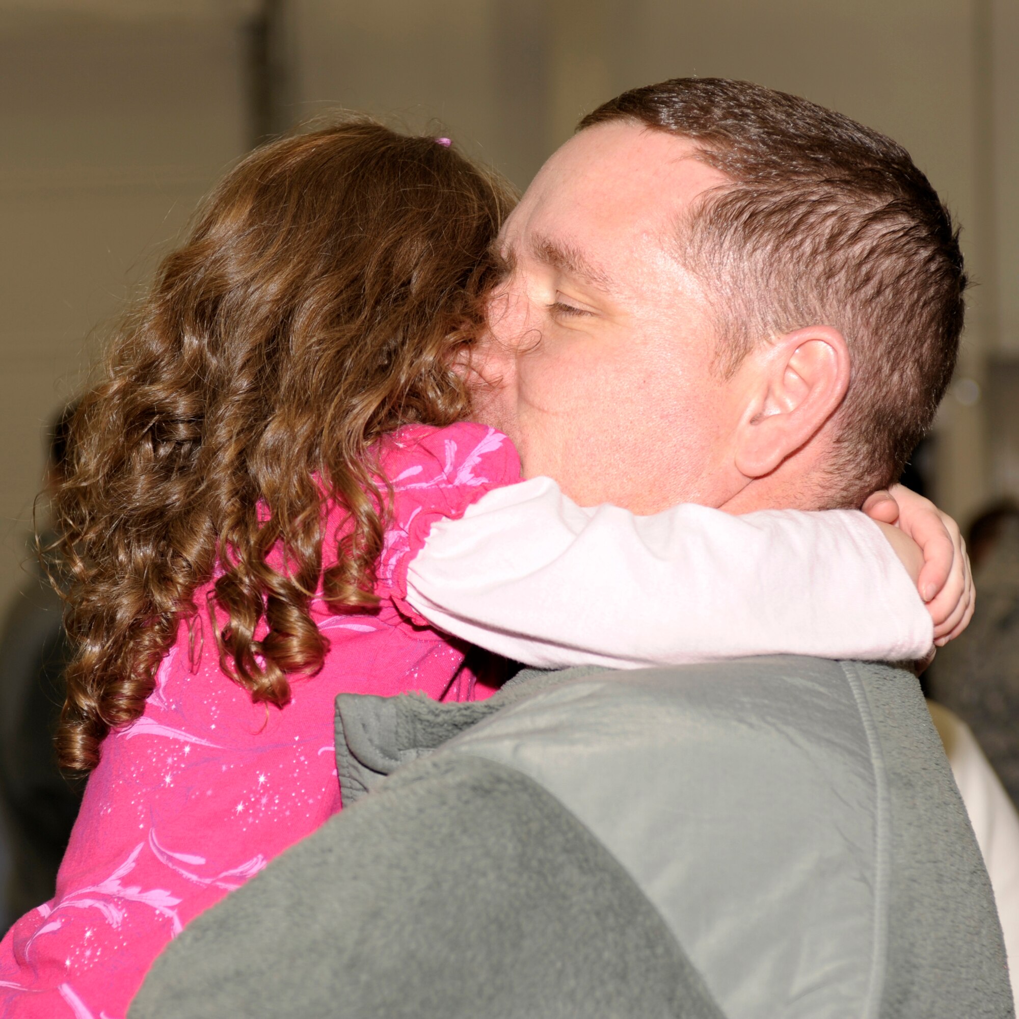 Master Sgt. Peter DeArmond, 16th Special Operations Squadron hugs his daughter Emily Elizabeth following his return from deployment March 9, 2011 at Cannon Air Force Base, N.M. Family and friends gathered in the hangar to welcome home their loved ones. (U.S. Air Force Photo by Airman Ericka Engblom)