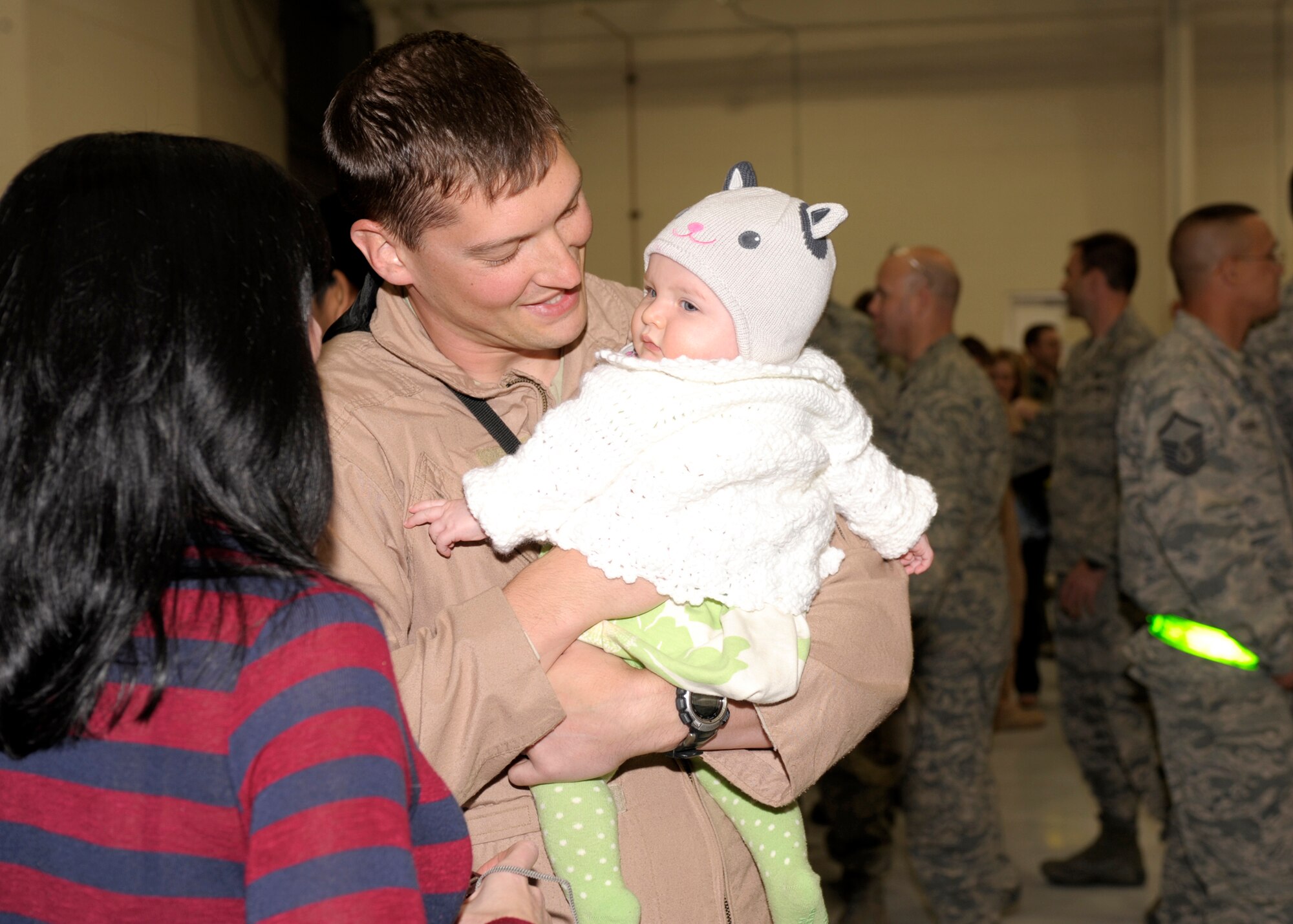 Capt. David Gibbons, 16th Special Operations Squadron, greets his baby gdaughter Sophia and his wife Ingrid in Hangar 196, Cannon Air Force Base, N.M, following his return from deployment March 9, 2011. Family and friends gathered  at Hangar 196 to welcome home their returning Air Commandos. (U.S. Air Force photo by Airman Ericka Engblom)