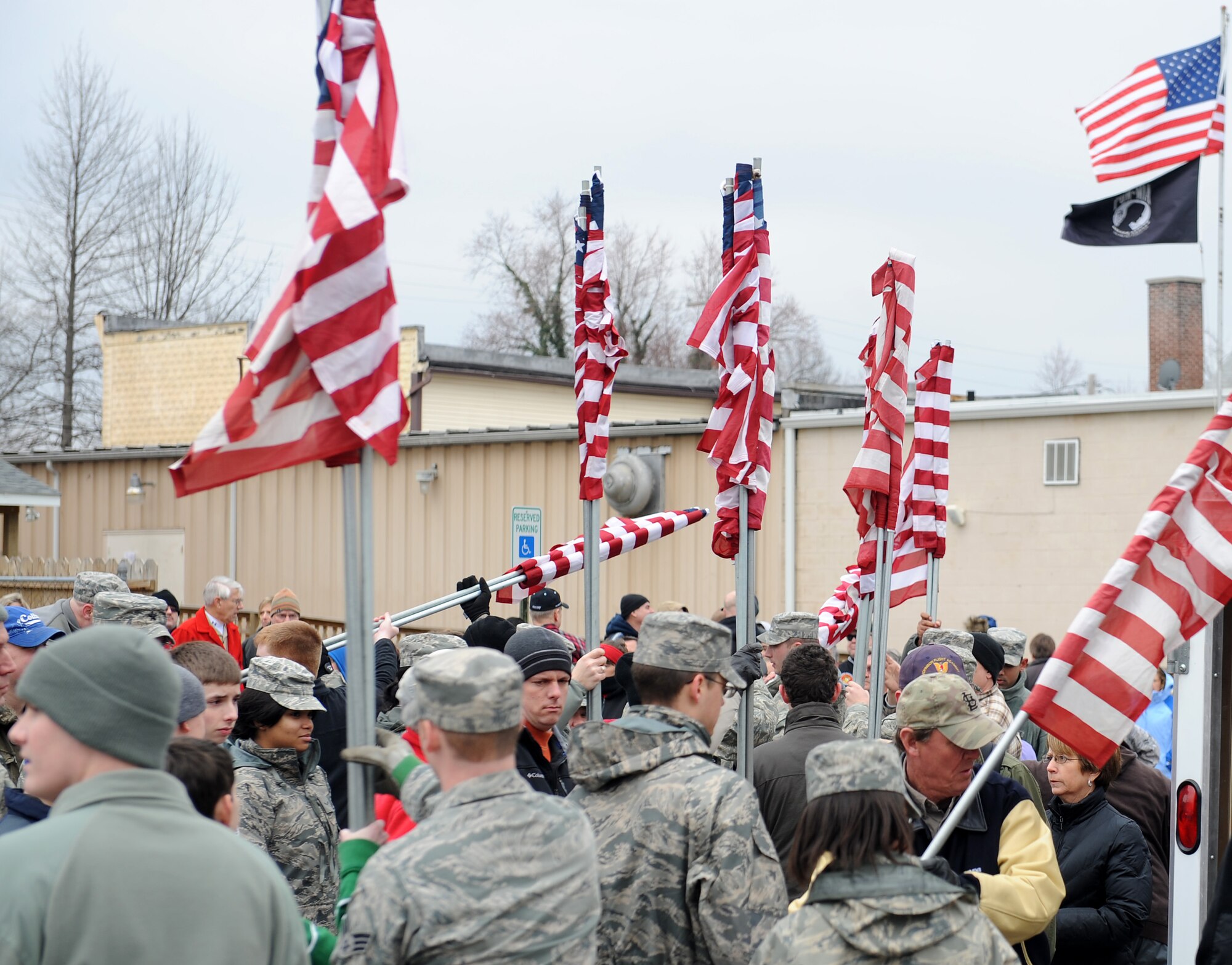 Volunteers from Scott Air Force Base, Ill. and the local area receive American Flags in preparation to line the procession route of Airman 1st Class Zachary Cuddeback March 10, 2011. Airman Cuddeback and another Airman were killed March 2, 2011 when a man opened fire on a bus of U.S. Airmen at an airport in Frankfurt, Germany.  Airman Cuddeback will be laid to rest next to his grandfather at a cemetery in O'Fallon, Ill. (U.S. Air Force photo/Airman 1st Class Divine Cox)