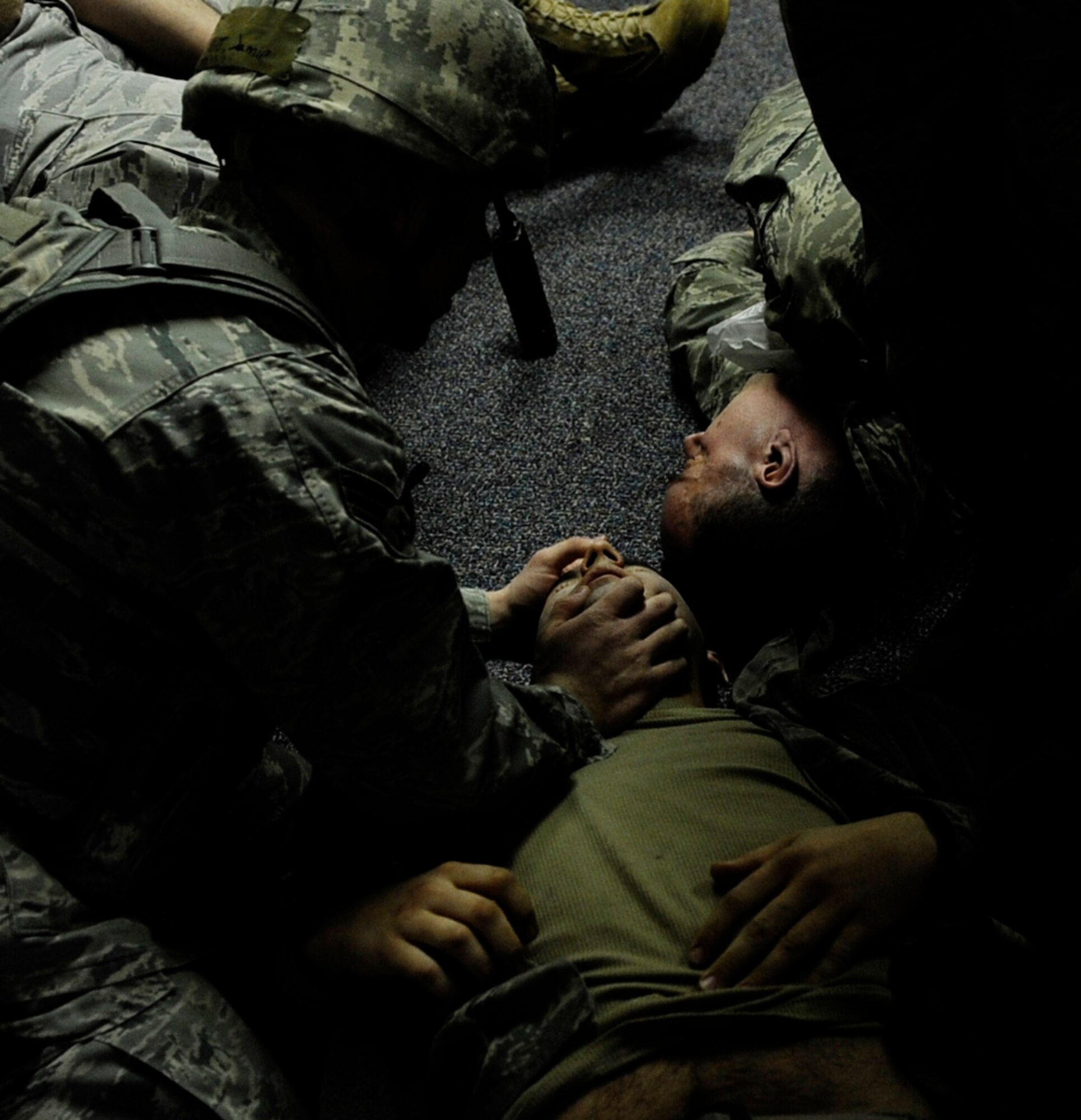 A Security Forces Airman checks a victim's airway during an operational readiness exercise March 9, 2011 Eielson Air Force Base, Alaska. Several Airmen donned moulage makeup and fake blood to simulate realistic looking injuries to assess the capabilities of Airmen providing self aid buddy care in a heightened threat environment. (U.S. Air Force photo/Airman 1st Class Laura Goodgame)