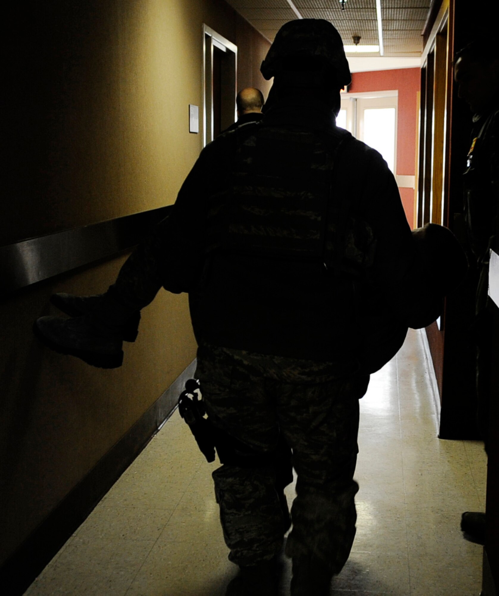 Security Forces Airman work together to carry the injured to a makeshift triage area during an operational readiness exercise March 9, 2011 Eielson Air Force Base, Alaska. The exercise is designed to  give Airmen experience in a simulated heightened environment. (U.S. Air Force photo/Airman 1st Class Laura Goodgame)