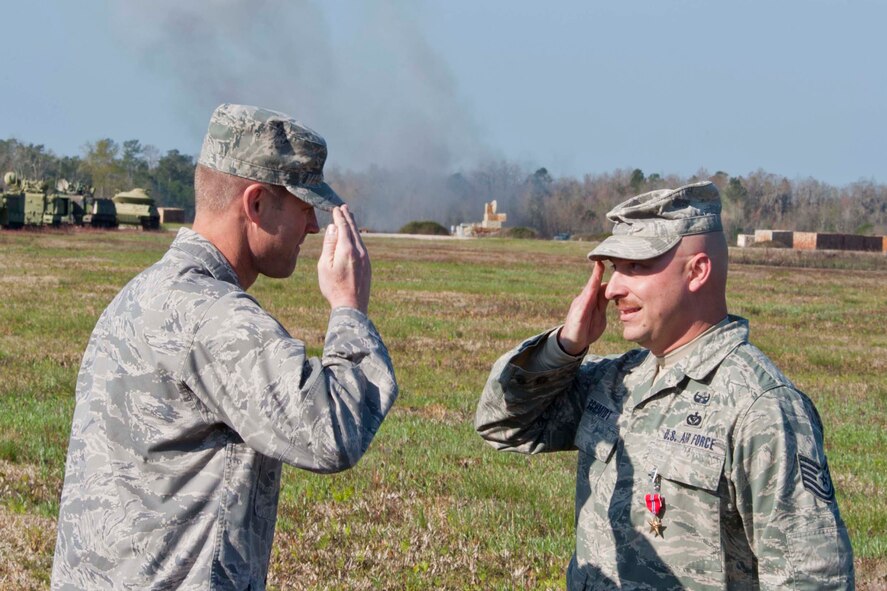Tech. Sgt. Richard Schmidt, 35th Civil Engineer Squadron explosive ordnance disposal craftsman, salutes Col. Gary Henderson, 23rd Wing commander, after receiving a Bronze Star Medal March 11 at the Grand Bay Bombing and Gunnery Range, Moody Air Force Base, Ga. During a recent deployment, Sergeant Schmidt’s leadership was critical to the successful execution of U.S. Central Command’s counter insurgency operations. (U.S. Air Force photo/Staff Sgt. Jamal D. Sutter)(RELEASED)