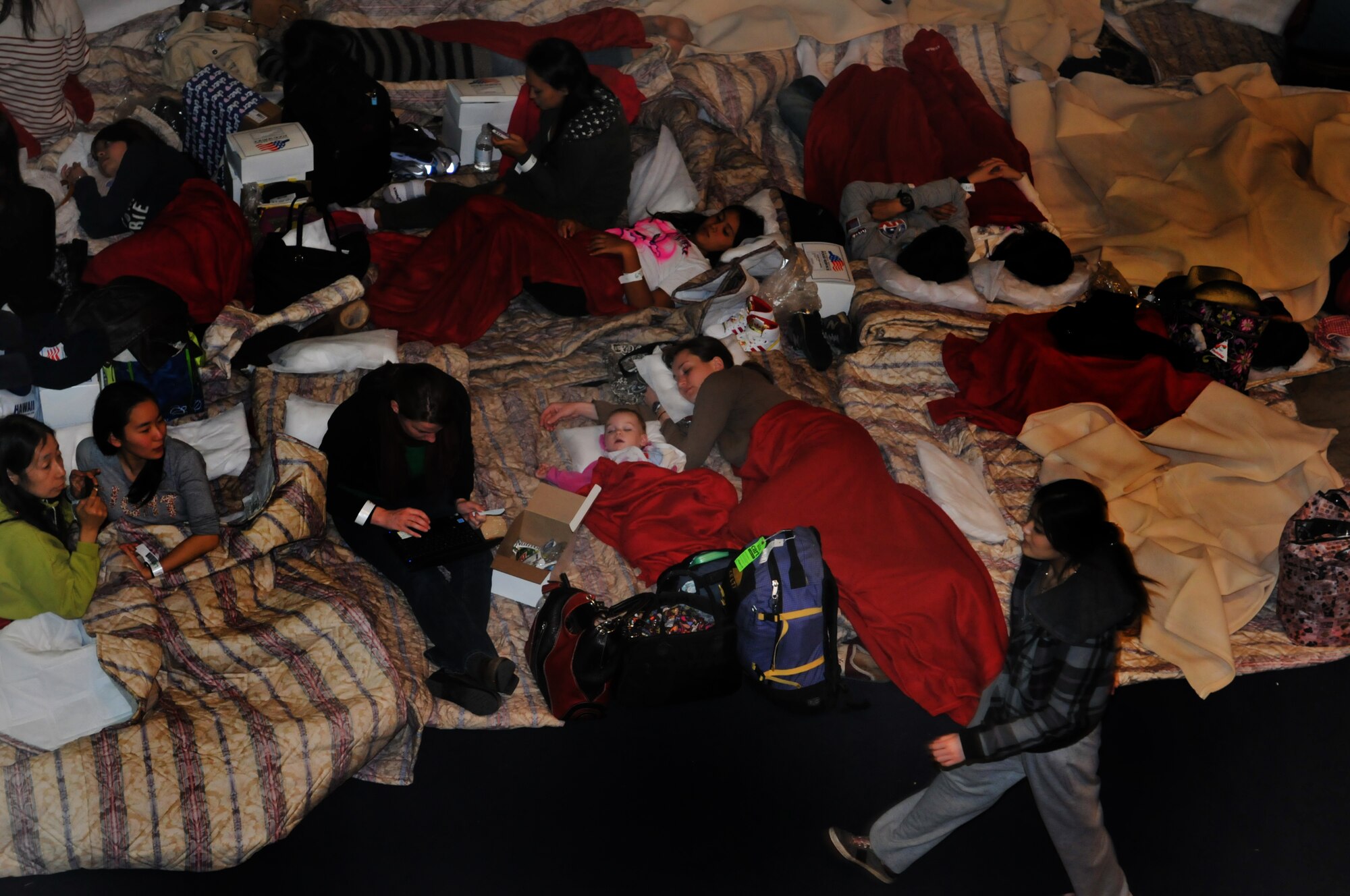 YOKOTA AIR BASE, Japan -- Delta Airline passengers sleep in the Taiyo Community Center here March 11. The passengers arrived to the base after their commercial flights were diverted from Narita International Airport, Tokyo, Japan, due to an earthquake struck near Tokyo. (U.S. Air Force photo/Airman John D. Partlow)