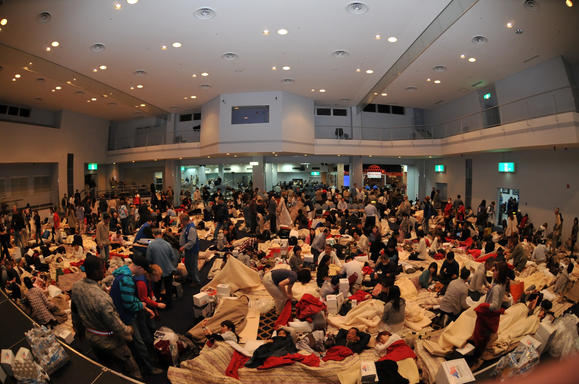 YOKOTA AIR BASE, Japan -- Delta Airline passengers take shelter inside the Taiyo Community Center here March 11. American Red Cross volunteers provided blankets, pillows, food and water for aircraft passengers whose planes were diverted from Narita International Airport, Tokyo, Japan, following an earthquake near Tokyo. (U.S. Air Force photo/Airman John D. Partlow)