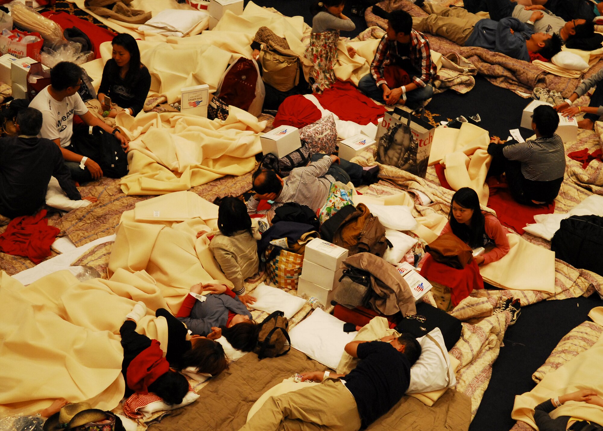 YOKOTA AIR BASE, Japan – Delta Airline passengers take shelter inside the Taiyo Community Center here March 11. The base provided food and lodging for airline passengers diverted from Narita International Airport, Tokyo, Japan, after an earthquake struck near Tokyo. (U.S. Air Force photo/Airman 1st Class Andrea Salazar)