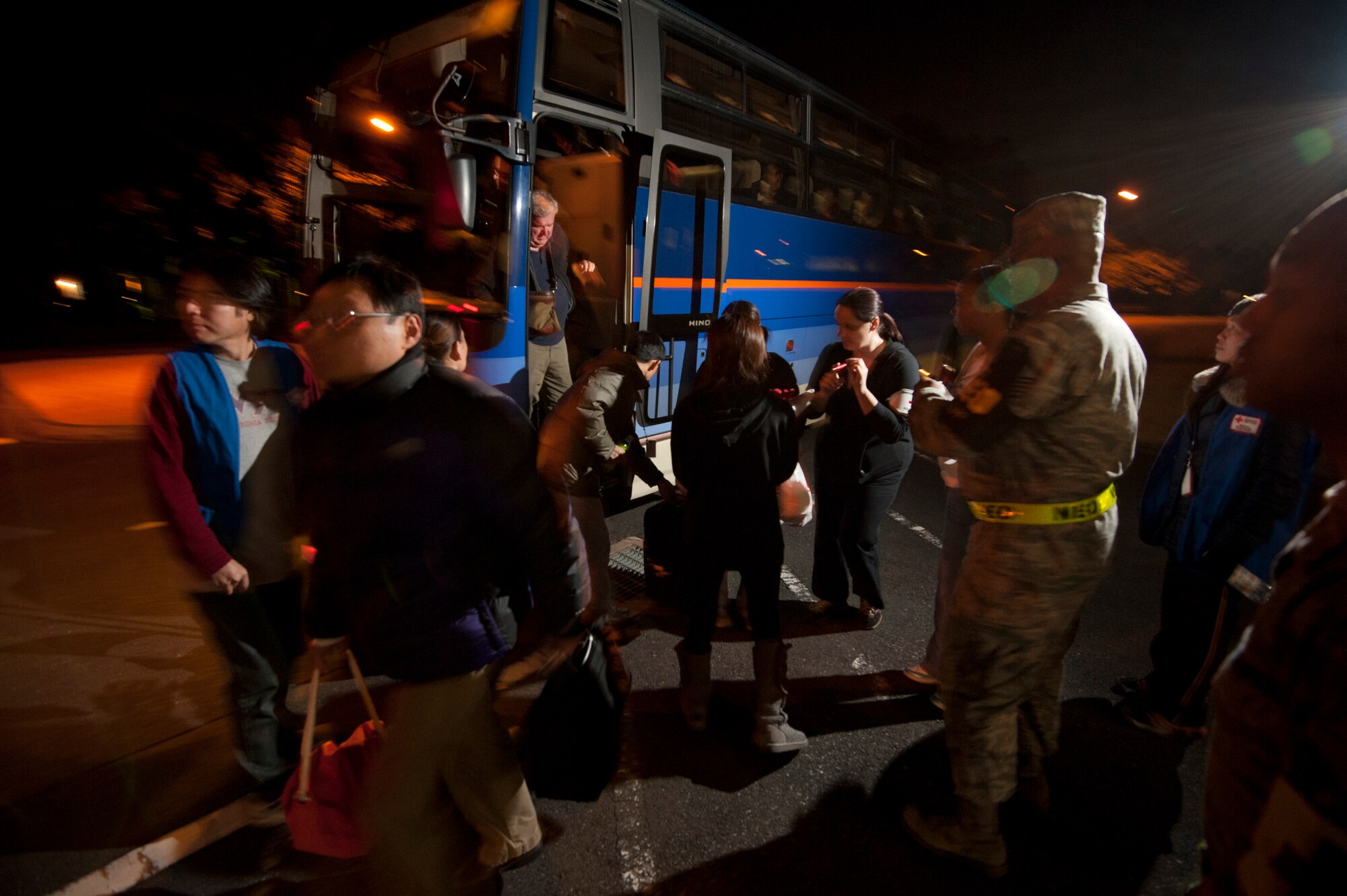 YOKOTA AIR BASE, Japan – Delta Airline passengers exit a bus at the Taiyo Community Center here March 11. The passengers were diverted here from Narita International Airport, Tokyo, Japan, after an earthquake struck near Tokyo. (U.S. Air Force photo/Staff Sgt. Samuel Morse)