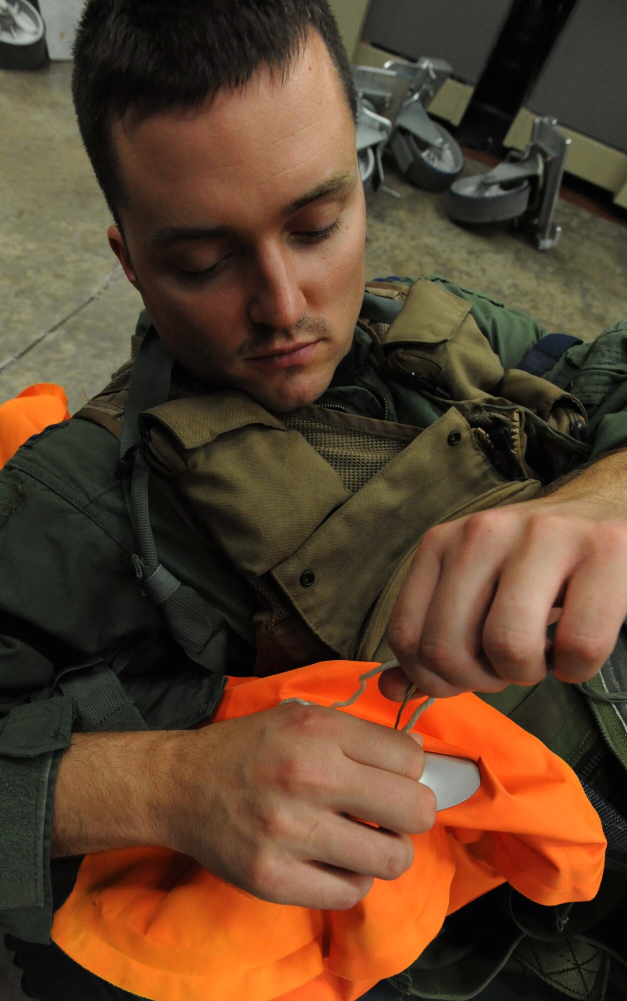 Capt. Stephen Koether, 535th Airlift Squadron pilot, demonstrates how to patch a hole in inflateable water survival equipment during an Operational Readiness Exercise Mar. 4 at Joint Base Pearl Harbor Hickam. The ORE tested Airmen's ability to respond to survive and operate during various wartime conditions. (U.S. Air Force photo/Staff Sgt. Nathan Allen)