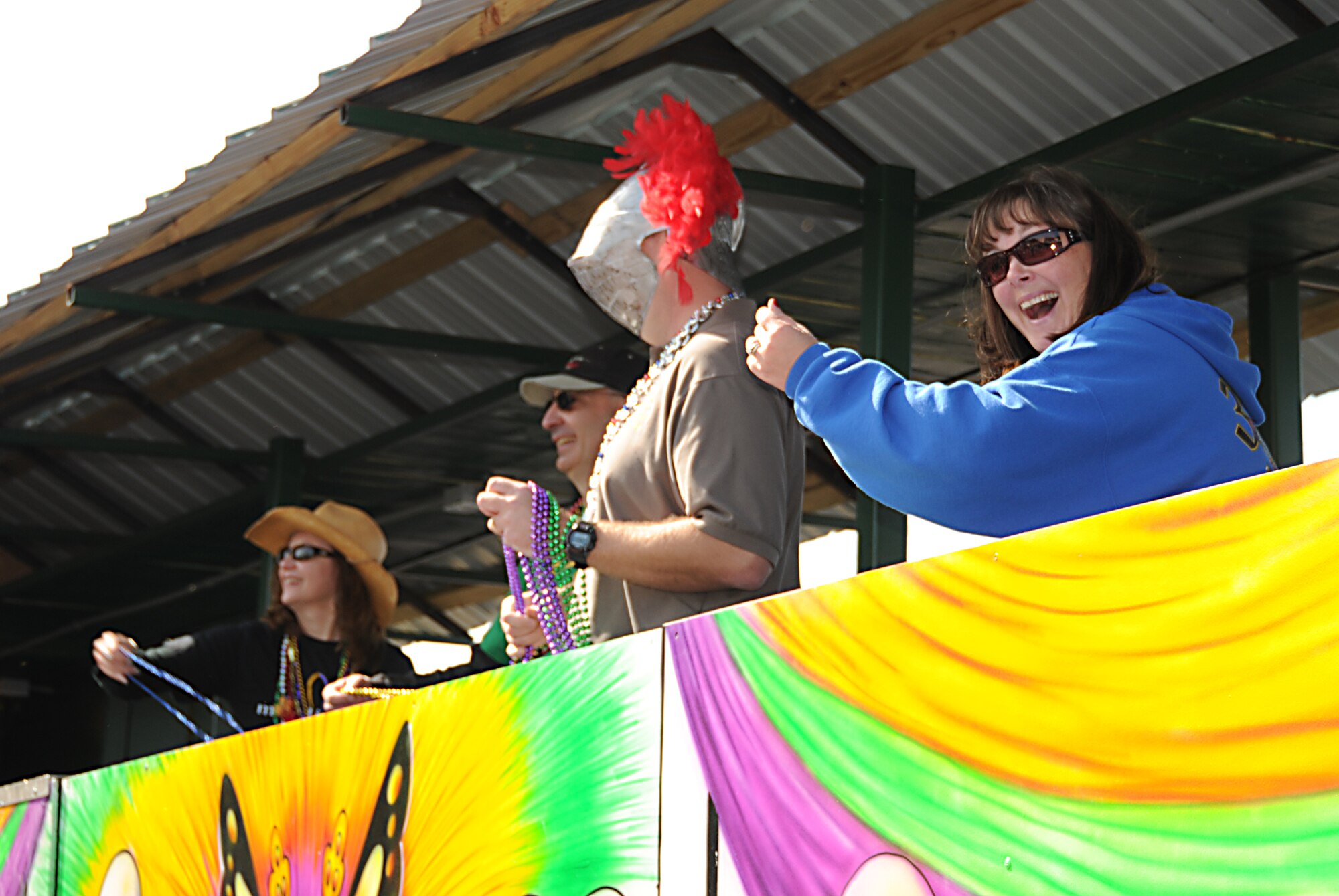 Nancy and Brig. Gen. James Muscatell, 403rd Wing commander, and Lt. Col. Daniel Gottrich, 338th Training Squadron commander, and his wife, Ainsley, toss beads to spectators from a float at Sunday’s North Bay Area Mardi Gras Association parade in D’Iberville.  (U.S. Air Force photo by Kemberly Groue)
