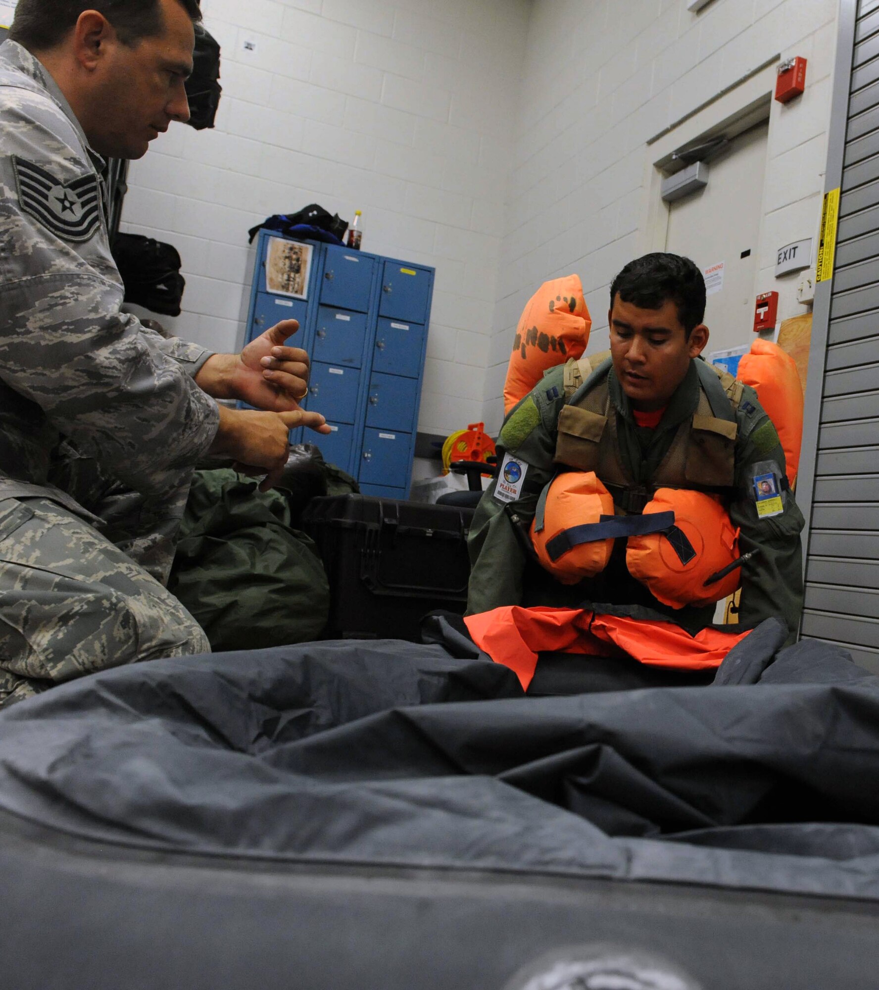Tech. Sgt. Sherwood Brown, 15th Operations Support Squadron survival, evasion, resistance, and escape specialist tests Capt. Gabriel Chavarra, 535th Airlift Squadron pilot, on water survival techniques during an Operational Readiness Exercise Mar. 4 at Joint Base Pearl Harbor Hickam. The ORE tested Airmen's ability to respond to survive and operate during various wartime conditions. (U.S. Air Force photo/Staff Sgt. Nathan Allen)