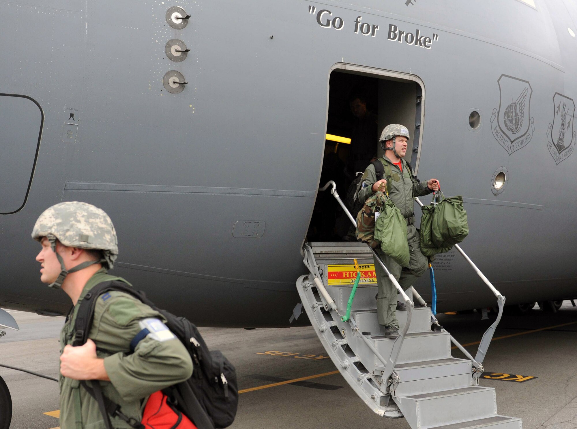 Capt. Stephen Koether, 535th Airlift Squadron pilot, and Staff Sgt. Robert Wyman, 535th AS loadmaster, deplane after landing during an Operational Readiness Exercise Mar. 4 at Joint Base Pearl Harbor Hickam. The ORE tested Airmen's ability to respond to survive and operate during various wartime conditions. (U.S. Air Force photo/Staff Sgt. Nathan Allen)