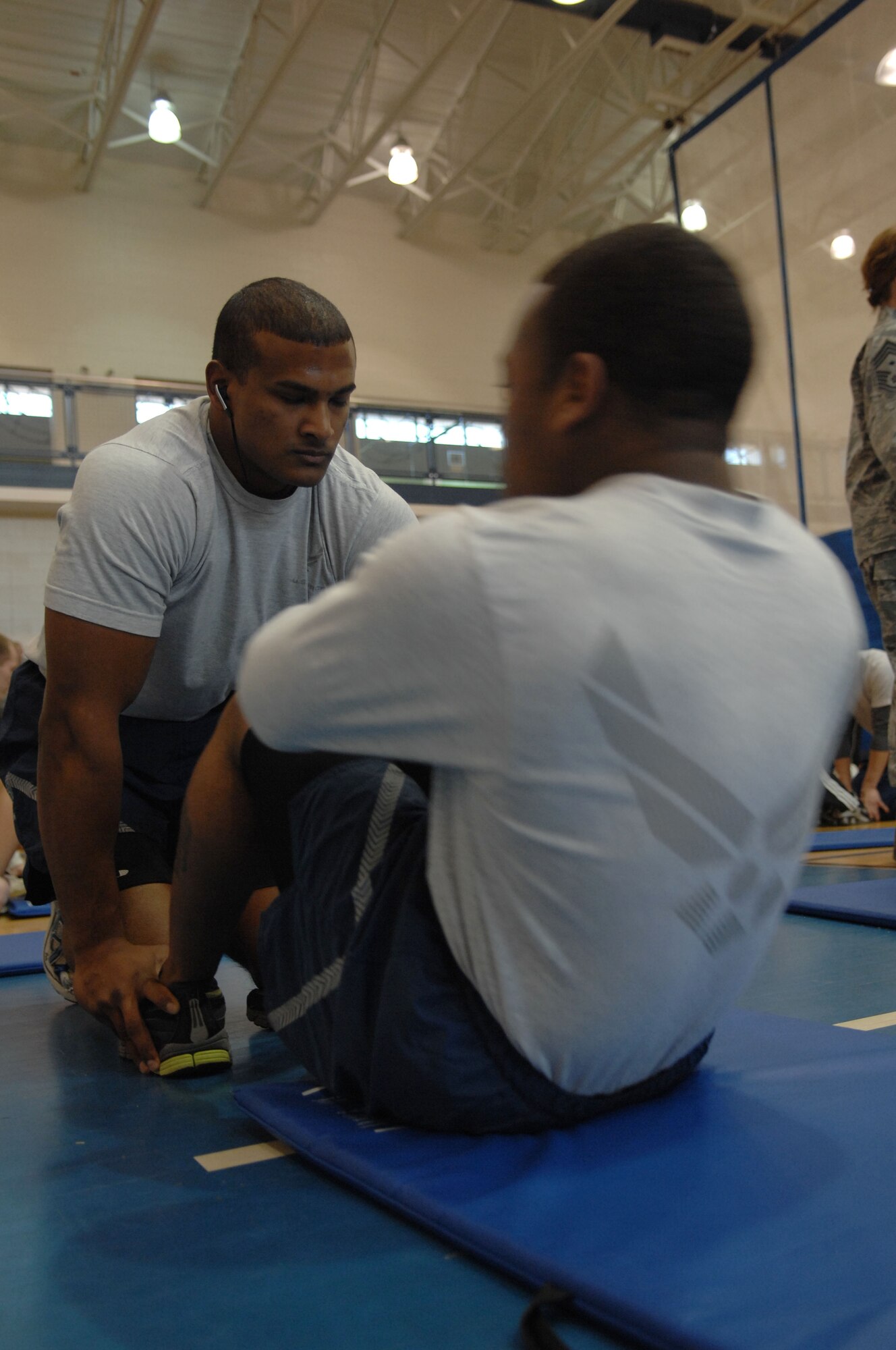 Airman 1st Class Kemal Baksh, 633d Aerospace Medicine Squadron public health technician, holds his teammate's feet during the Push-up-A-Thon/Sit-up-A-Thon at Langley Air Force Base, Va., March 11, 2011. Team Physical Health competed along side 57 other participants, completing a total of 14,367 push-ups and sit-ups.(U.S. Air Force photo by Airman 1st Class Racheal Watson/Released)