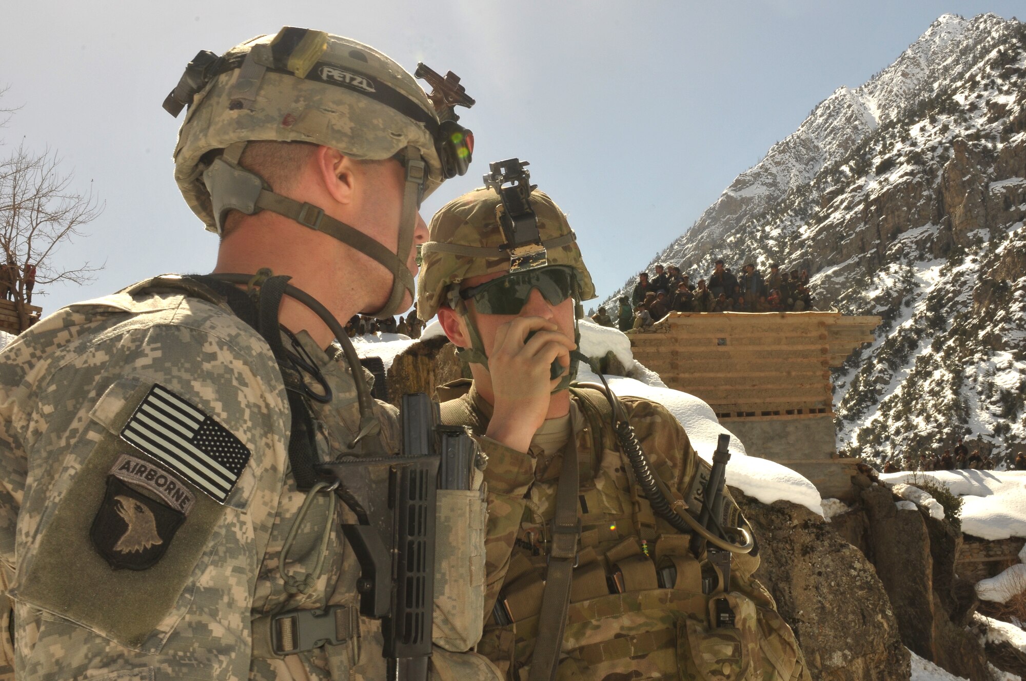 Barge Matal, Afghanistan – U.S. Army soldiers responsible for providing security communicate over radio during a combat resupply mission in Barge Matal in the northern Kunar Valley March 10. The Afghan Air Force worked in cooperation with the Ministry of the Interior and coalition forces to complete the mission, using ten aircraft to deliver over 9,000 kilograms of weapons, ammunition and food to Afghan National Police stationed in the remote post that is seen as vital by Afghan officials due to its proximity to Pakistan and history of insurgent activity. Following the supply drop-off, forces loaded over 80 ANP bound for their respective homes following a three to six month deployment to the region. (U.S. Navy photo by Mass Communications Specialist 2nd Class Vladimir Potapenko).

