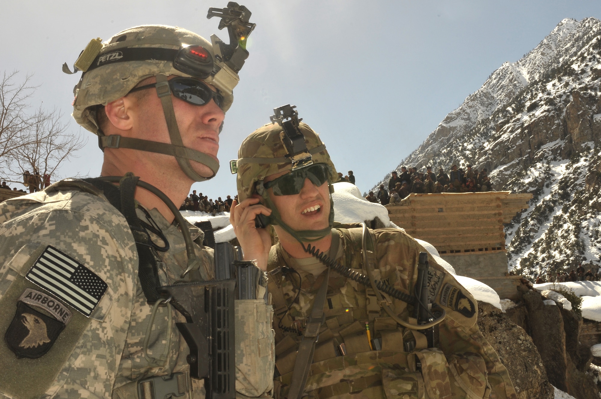 Barge Matal, Afghanistan – U.S. Army soldiers responsible for providing security listen for instruction over radio during a combat resupply mission in Barge Matal in the northern Kunar Valley March 10. The Afghan Air Force worked in cooperation with the Ministry of the Interior and coalition forces to complete the mission, using ten aircraft to deliver over 9,000 kilograms of weapons, ammunition and food to Afghan National Police stationed in the remote post that is seen as vital by Afghan officials due to its proximity to Pakistan and history of insurgent activity. Following the supply drop-off, forces loaded over 80 ANP bound for their respective homes following a three to six month deployment to the region. (U.S. Navy photo by Mass Communications Specialist 2nd Class Vladimir Potapenko).