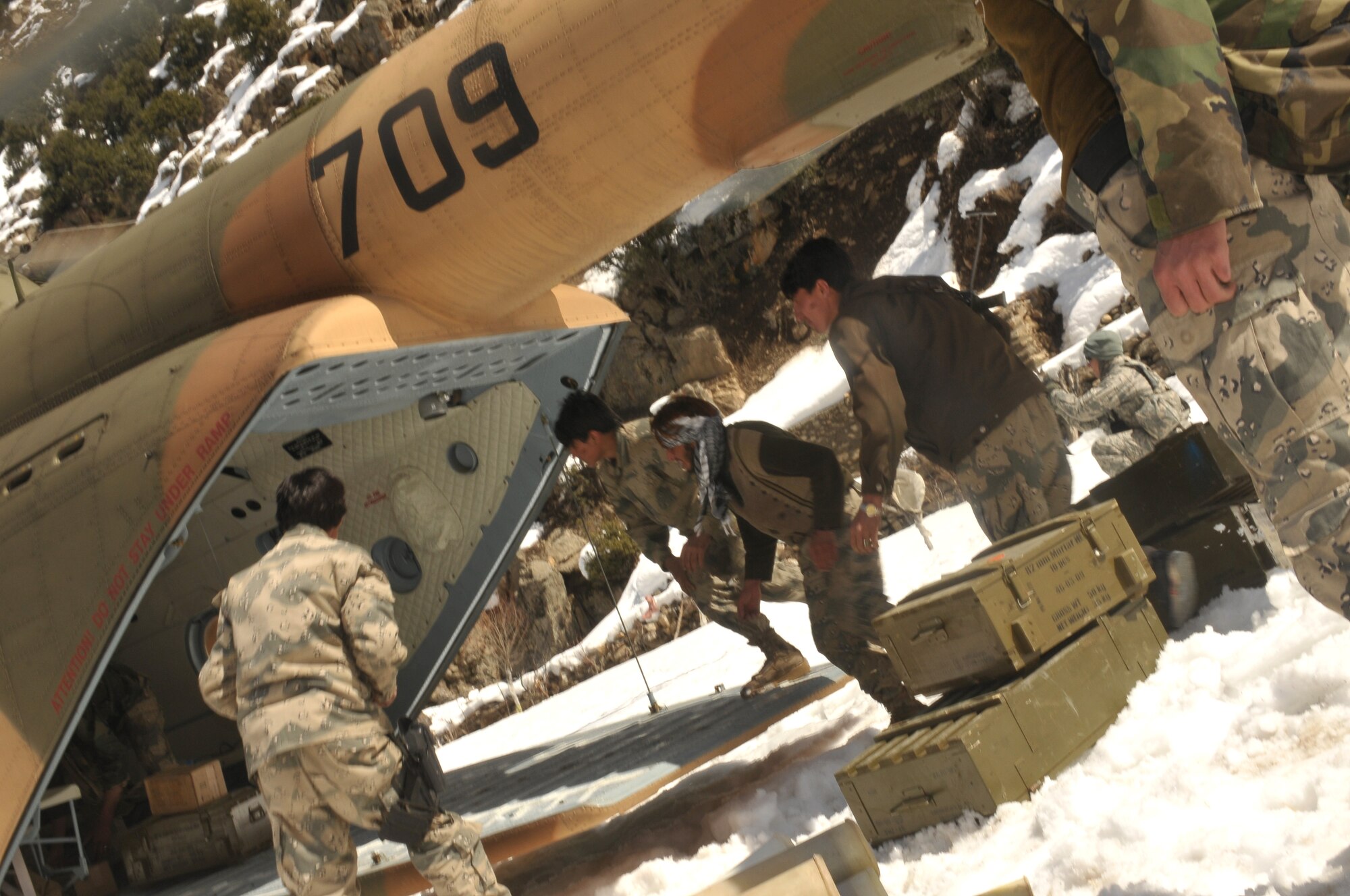Barge Matal, Afghanistan – Afghan National Police troops remove provisions from the back of an Afghan Air Force Mi-17 transport helicopter during a combat resupply mission in Barge Matal in the northern Kunar Valley March 10. The Afghan Air Force worked in cooperation with the Ministry of the Interior and coalition forces to complete the mission, using ten aircraft to deliver over 9,000 kilograms of weapons, ammunition and food to Afghan National Police stationed in the remote post that is seen as vital by Afghan officials due to its proximity to Pakistan and history of insurgent activity. Following the supply drop-off, forces loaded over 80 ANP bound for their respective homes following a three to six month deployment to the region. (U.S. Navy photo by Mass Communications Specialist 2nd Class Vladimir Potapenko).