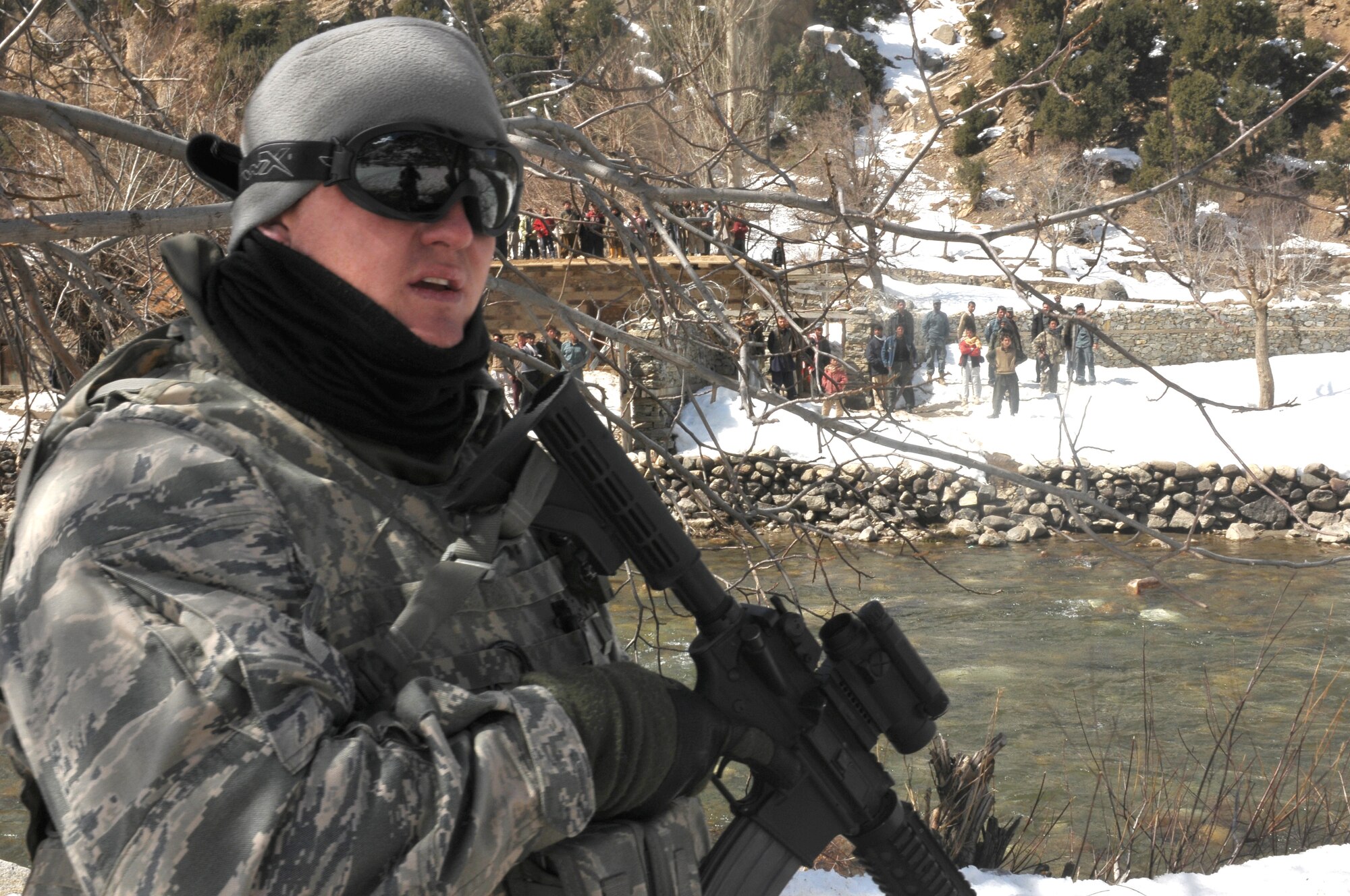 Barge Matal, Afghanistan – U.S. Air Force Capt. Drew Walters, a NATO Air Training Command-Afghanistan tactical coordination advisor, originally from Alamosa, Colo., provides security watch during a combat resupply mission in Barge Matal in the northern Kunar Valley March 10. The Afghan Air Force worked in cooperation with the Ministry of the Interior and coalition forces to complete the mission, using ten aircraft to deliver over 9,000 kilograms of weapons, ammunition and food to Afghan National Police stationed in the remote post that is seen as vital by Afghan officials due to its proximity to Pakistan and history of insurgent activity. Following the supply drop-off, forces loaded over 80 ANP bound for their respective homes following a three to six month deployment to the region. (U.S. Navy photo by Mass Communications Specialist 2nd Class Vladimir Potapenko).