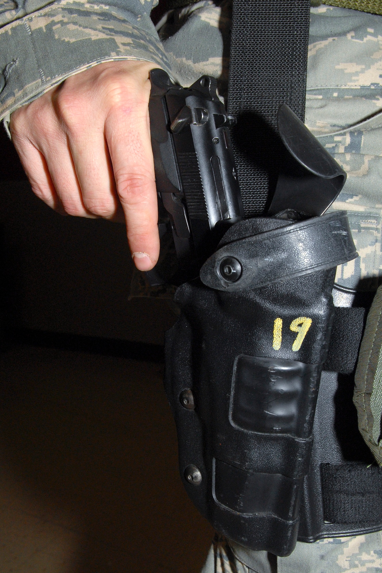 Staff Sgt. Tim Streets, 436th Security Forces Squadron combat arms instructor, demonstrates how to holster an M-9 pistol, March, 4 2011, at the Combat Arms Training and Maintenance facility on Dover Air Force Base, Del.   