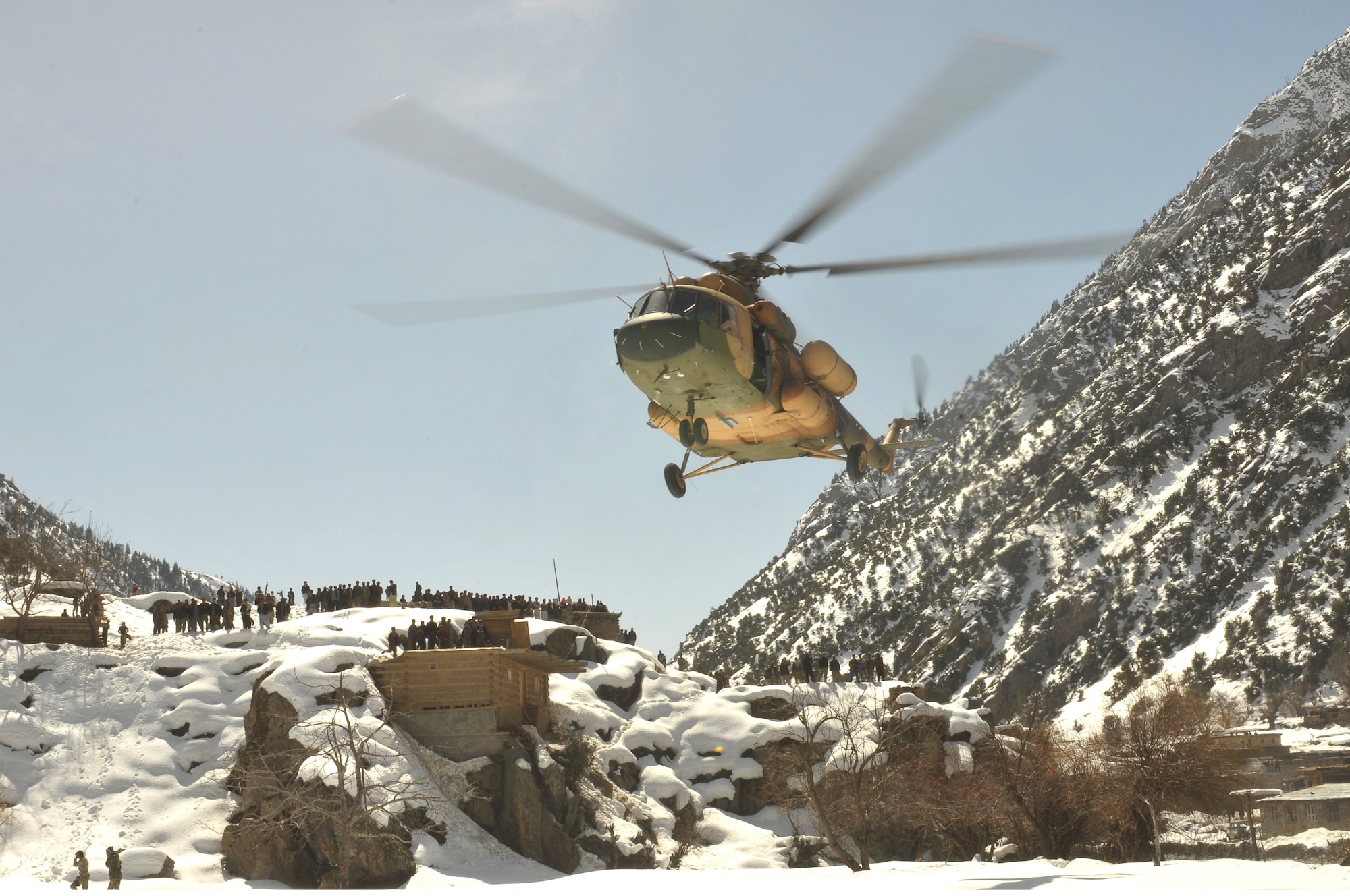 Barge Matal, Afghanistan – An Afghan Air Force Mi-17 transport helicopter descends for a landing during a combat resupply mission in Barge Matal in the northern Kunar Valley March 10. The AAF worked in cooperation with the Ministry of the Interior and coalition forces to complete the mission, using ten aircraft to deliver over 9,000 kilograms of weapons, ammunition and food to Afghan National Police stationed in the remote post that is seen as vital by Afghan officials due to its proximity to Pakistan and history of insurgent activity. Following the supply drop-off, forces loaded over 80 ANP bound for their respective homes following a three to six month deployment to the region. (U.S. Navy photo by Mass Communications Specialist 2nd Class Vladimir Potapenko).