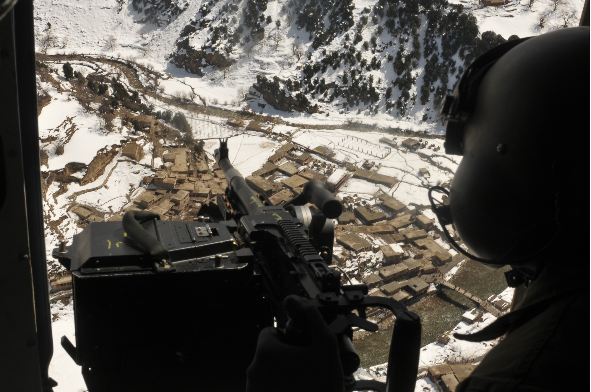 Barge Matal, Afghanistan – An Afghan Air Force Airmen surveys the surrounding area for possible insurgents as an AAF Mi-17 transport helicopter descends for a landing during a combat resupply mission in Barge Matal in the northern Kunar Valley March 10. The AAF worked in cooperation with the Ministry of the Interior and coalition forces to complete the mission, using ten aircraft to deliver over 9,000 kilograms of weapons, ammunition and food to Afghan National Police stationed in the remote post that is seen as vital by Afghan officials due to its proximity to Pakistan and history of insurgent activity. Following the supply drop-off, forces loaded over 80 ANP bound for their respective homes following a three to six month deployment to the region. (U.S. Navy photo by Mass Communications Specialist 2nd Class Vladimir Potapenko).