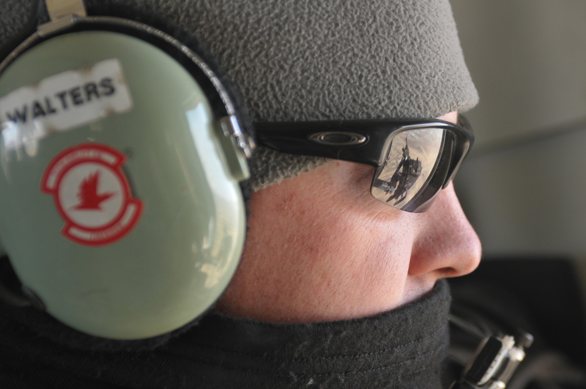 Barge Matal, Afghanistan – U.S. Air Force Capt. Drew Walters, a NATO Air Training Command-Afghanistan tactical coordination advisor, originally from Alamosa, Colo., provides security watch during a combat resupply mission in Barge Matal in the northern Kunar Valley March 10. The Afghan Air Force worked in cooperation with the Ministry of the Interior and coalition forces to complete the mission, using ten aircraft to deliver over 9,000 kilograms of weapons, ammunition and food to Afghan National Police stationed in the remote post that is seen as vital by Afghan officials due to its proximity to Pakistan and history of insurgent activity. Following the supply drop-off, forces loaded over 80 ANP bound for their respective homes following a three to six month deployment to the region. (U.S. Navy photo by Mass Communications Specialist 2nd Class Vladimir Potapenko).