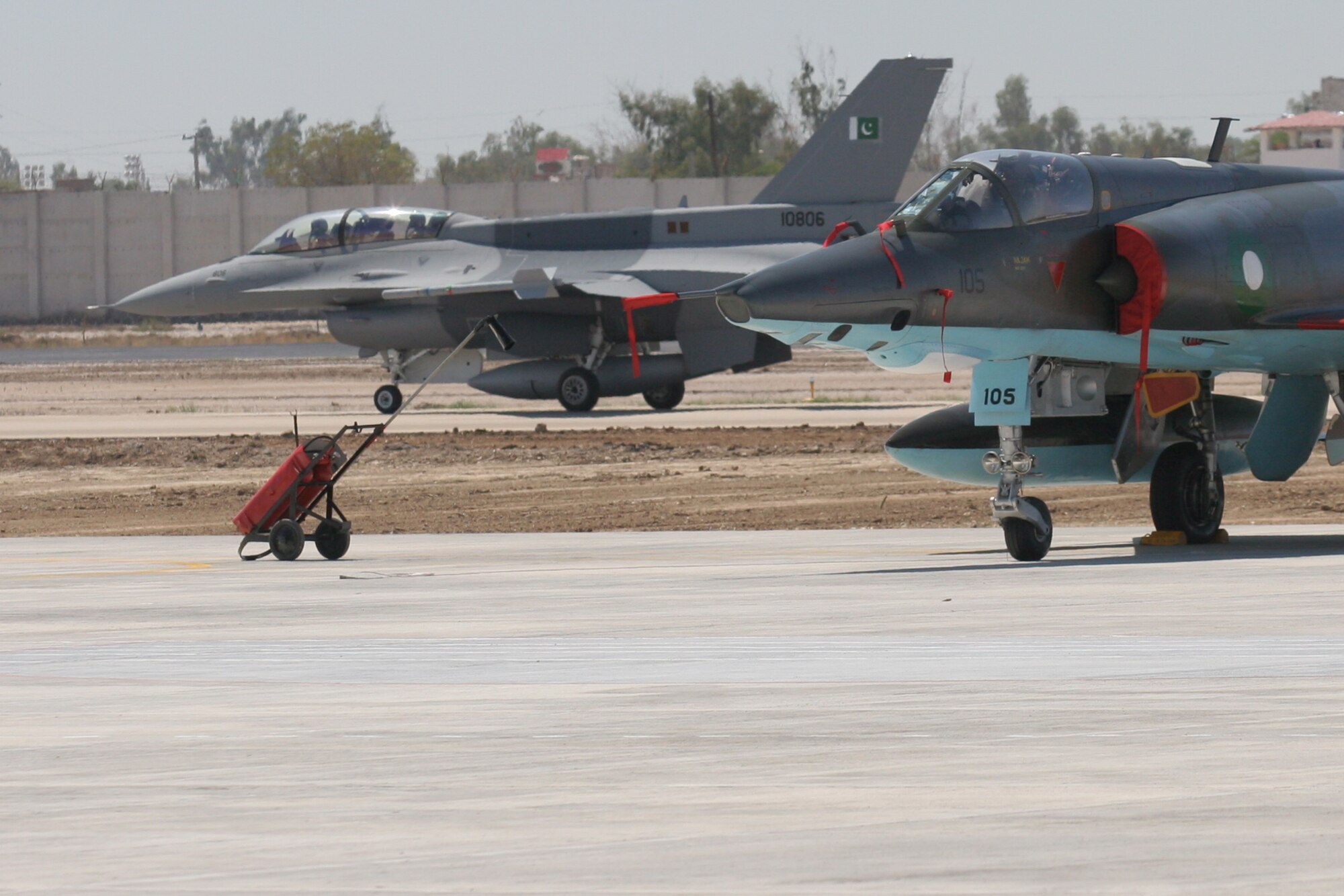 A Pakistani Air Force F-16 taxis past a Pakistan Air Force Mirage fighter jet on the runway at Pakistan Air Force Base Shahbaz near Jacobabad, Pakistan.  The F-16s belongs to the new re-designated Squadron 5 and replaces the older Mirage aircraft.  The Pakistan Air Force conducted a re-equipping ceremony on March 10 which was attended by Maj. Gen. Richard Shook, the Individual Mobilization Augmentee to Lt. Gen. Mike Hostage, U.S. Air Forces Central commander.  (U.S. Air Force photo by Lt. Col. Michael Shavers)