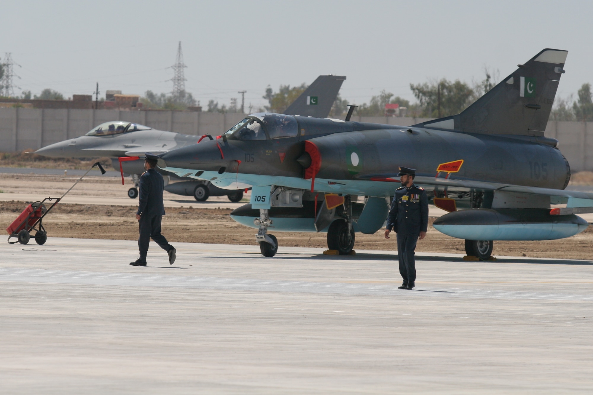 A Pakistani Air Force F-16 taxis past a Pakistan Air Force Mirage fighter jet on the runway at Pakistan Air Force Base Shahbaz near Jacobabad, Pakistan.  The F-16s belongs to the new re-designated Squadron 5 and replaces the older Mirage aircraft.  The Pakistan Air Force conducted a re-equipping ceremony on March 10 which was attended by Maj. Gen. Richard Shook, the Individual Mobilization Augmentee to Lt. Gen. Mike Hostage, U.S. Air Forces Central commander.  (U.S. Air Force photo by Lt. Col. Michael Shavers)