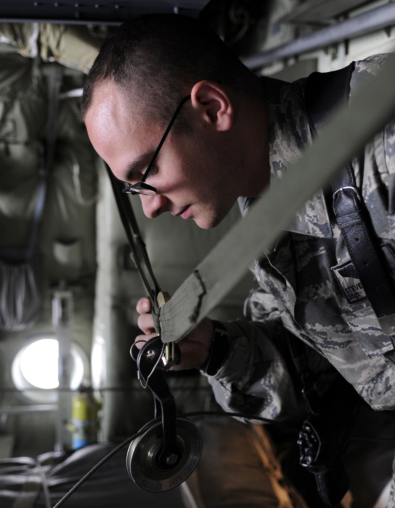 Staff Sgt. Steven Smith inspects the retriever pulley, March 11, 2011, at Kandahar Airfield, Afghanistan. Sergeant Smith inspects bundled cargo to ensure it is loaded correctly and will therefore deploy correctly. Sergeant Smith is a joint airdrop inspector assigned to the 451st Air Expeditionary Wing. (U.S. Air Force photo/Senior Airman Willard E. Grande II/Released)