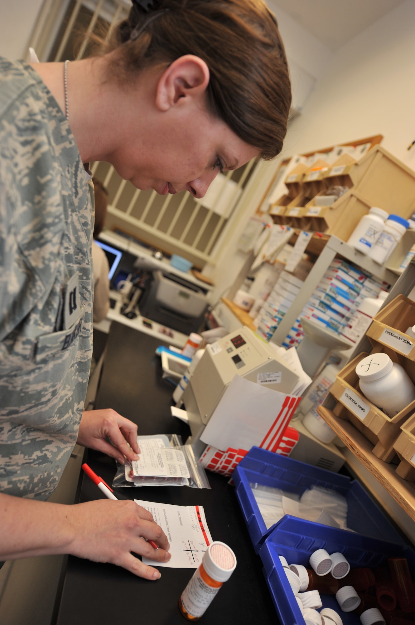 Capt. Jennifer Baker, 455th Expeditionary Medical Support Squadron chief of pharmacy services, does a final check before providing the medication to the patient at Bagram Airfield, Afghanistan, March 3, 2011. The final check before dispensing the medicine is the last process at the pharmacy to ensure all the necessary checks have been made such as the quantity, labels, expiration date, and product. (U.S. Air Force photo by Senior Airman Sheila deVera)